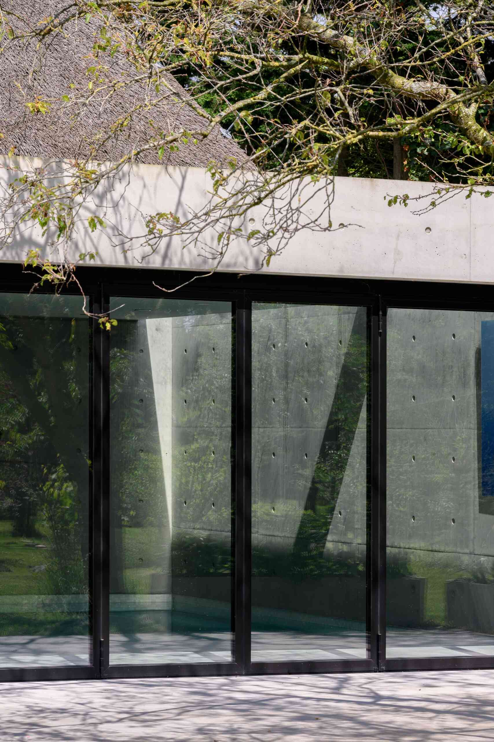 Llamativa extensión de bienestar con piscina, sauna y paredes de cristal plegables con acceso total a la terraza exterior.