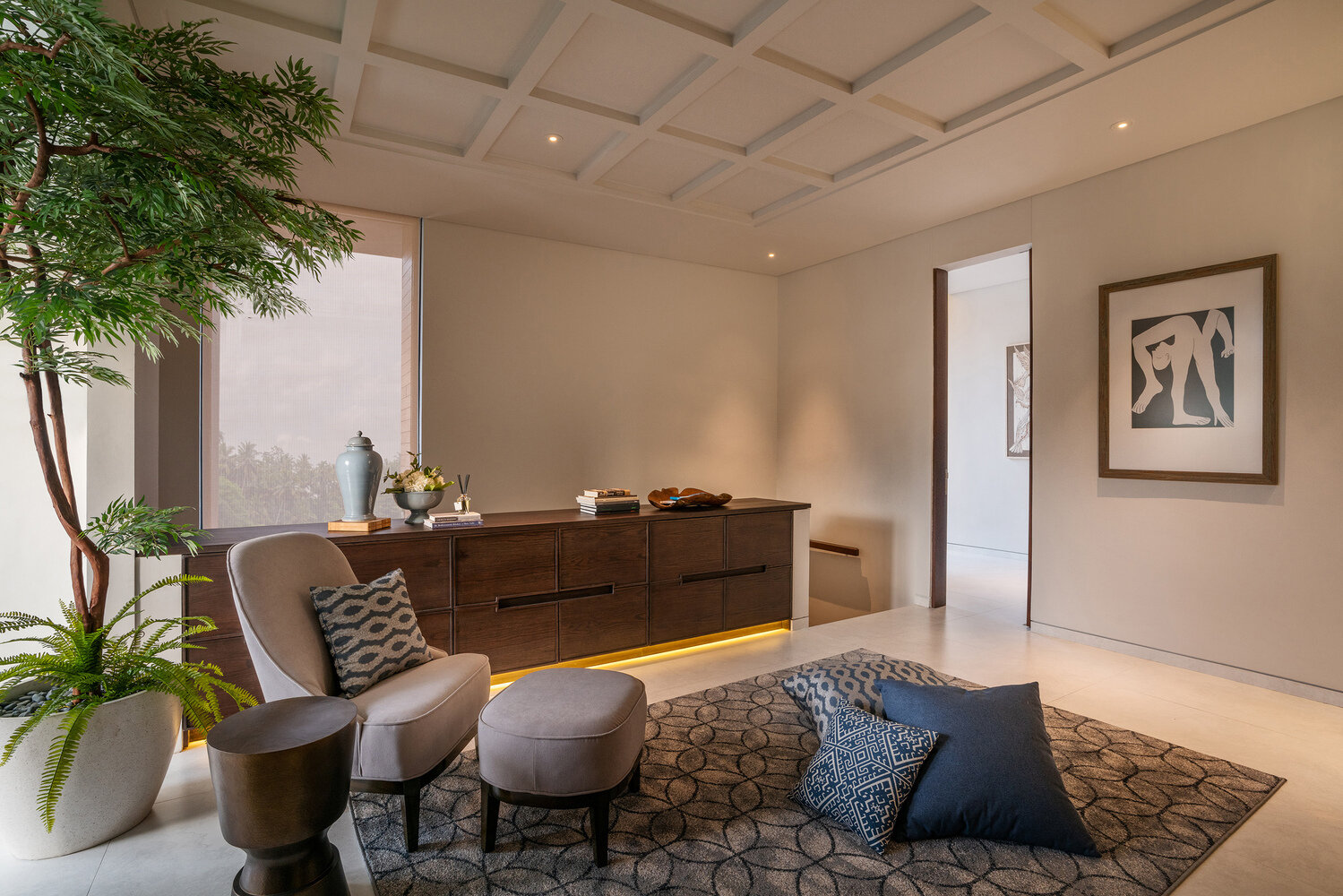 A sitting space offers a quieter zone, complete with a sideboard that features hidden lighting underneath, adding a soft glow without overwhelming the room.