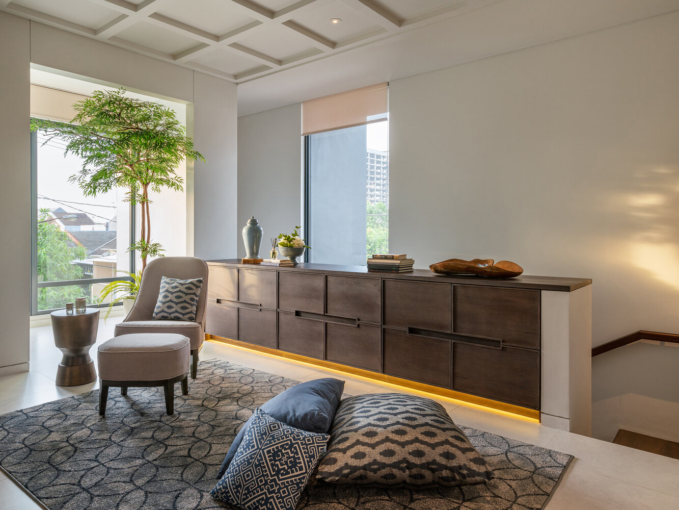 A sitting space offers a quieter zone, complete with a sideboard that features hidden lighting underneath, adding a soft glow without overwhelming the room.