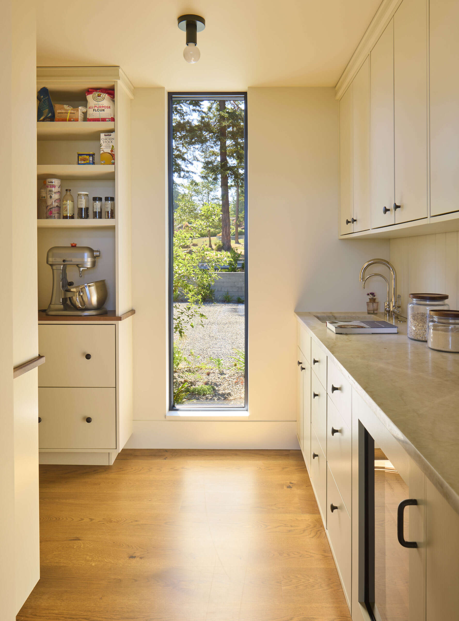 A walk-in pantry keeps storage and prep out of sight, helping the kitchen stay clean and organized.