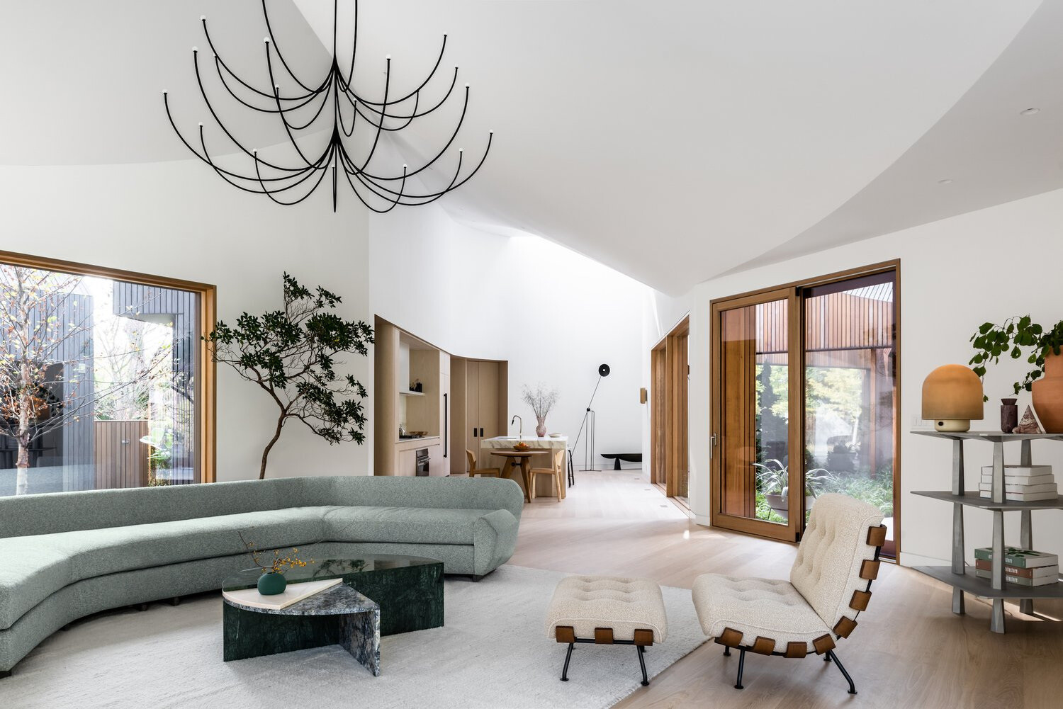 A bright white interior with angled ceilings reflects the home’s sculptural roofline, creating an open and airy atmosphere.