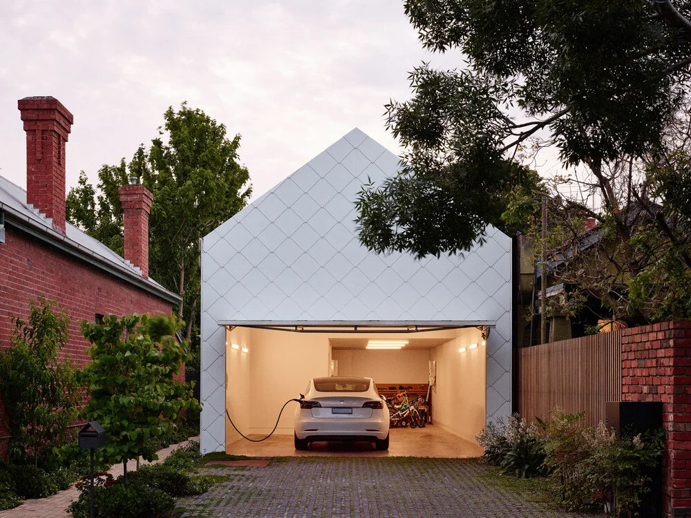 White Flat Lock metal shingles and a pitched roof give this home a clean, textured look that feels both modern and familiar.