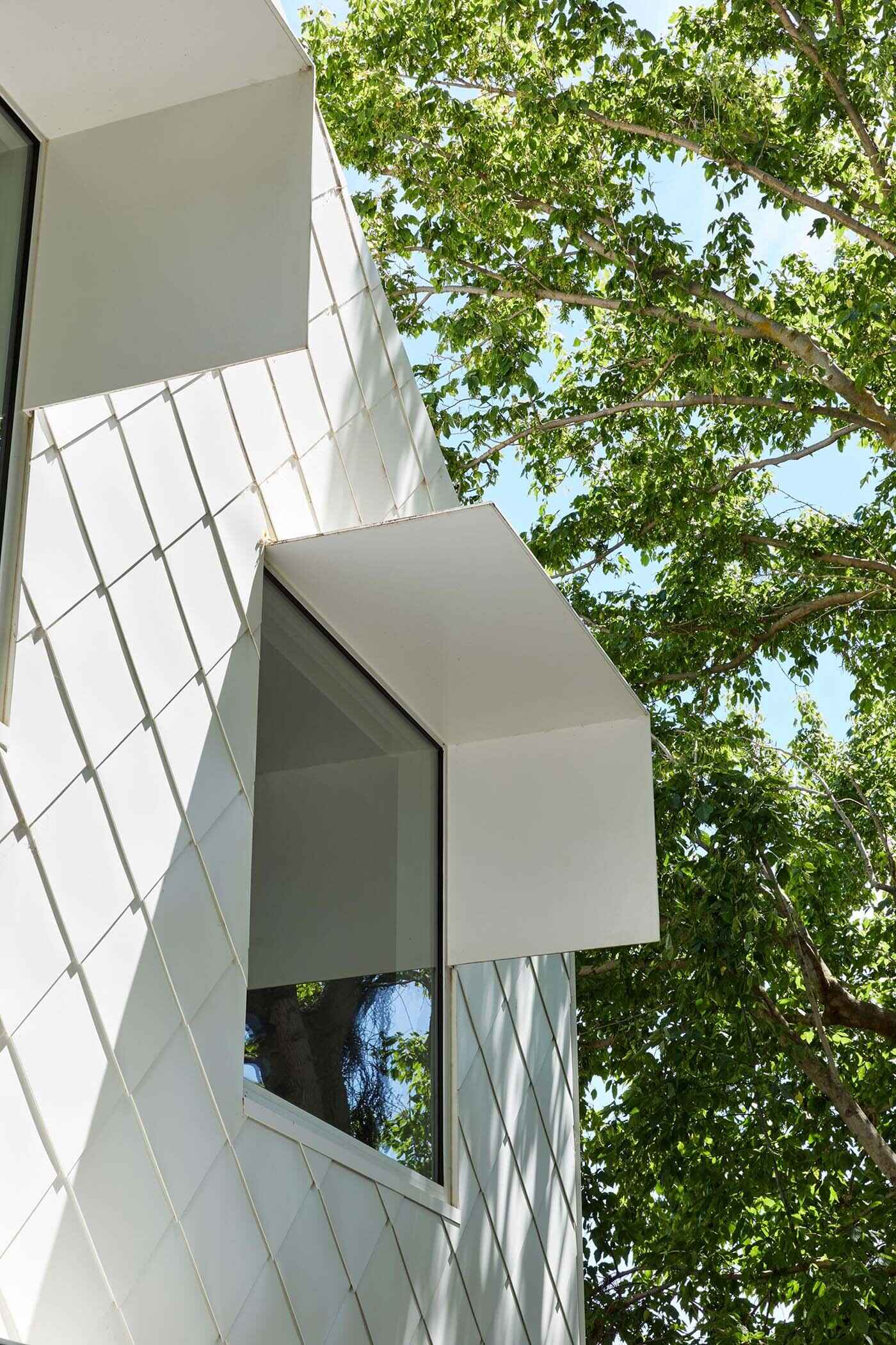 Metal awnings extend outward to provide shade while adding depth and structure to the facade.