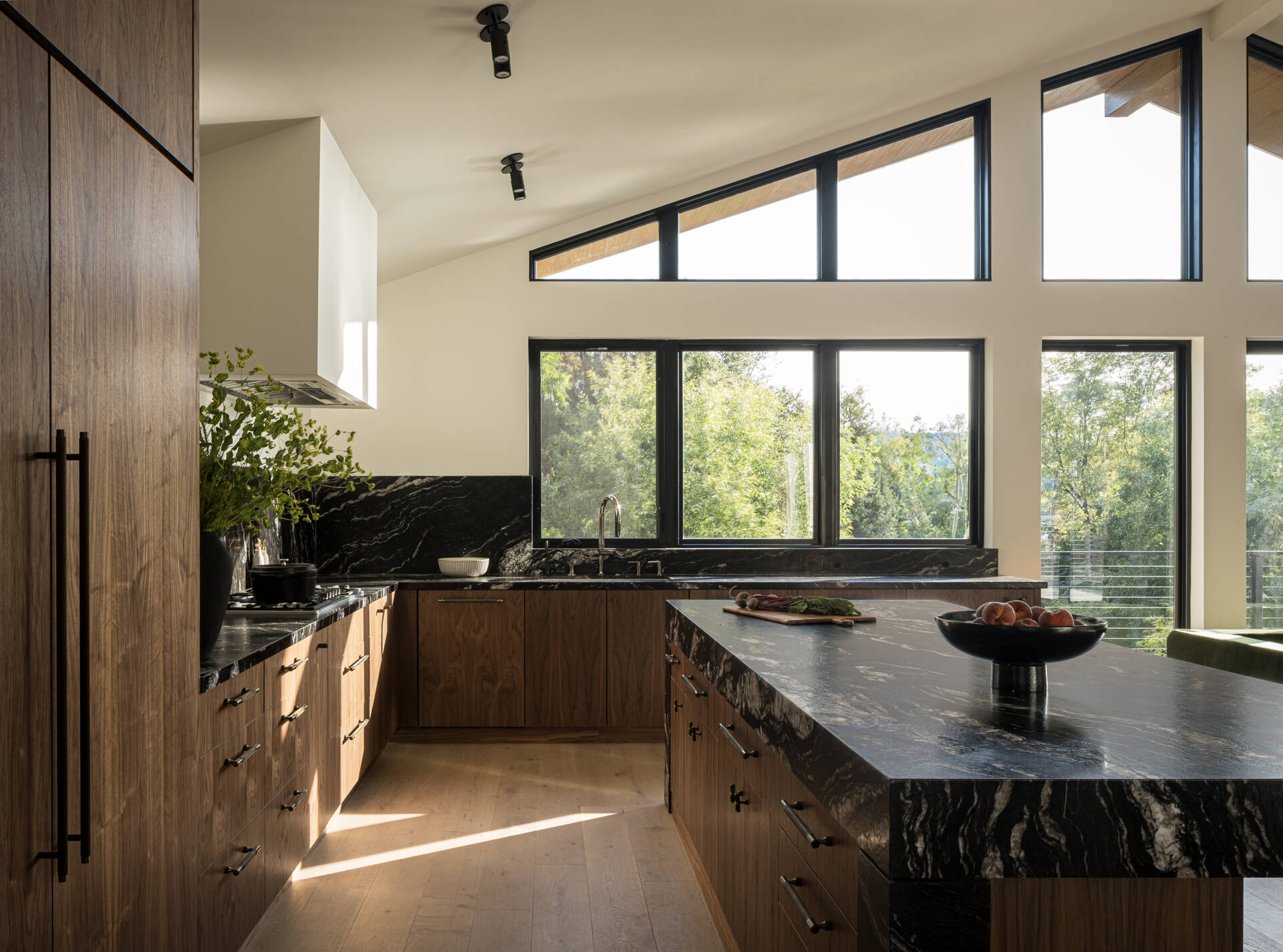 The kitchen anchors the main level, forming part of the great room alongside the breakfast nook and family lounge. It’s designed for both daily use and larger gatherings, with durable materials like leather-finished dark stone countertops and wood cabinets, adding depth and contrast.