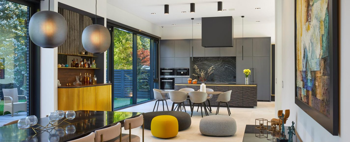 An open-plan kitchen and dining space with dual dining areas and seamless indoor-outdoor flooring.