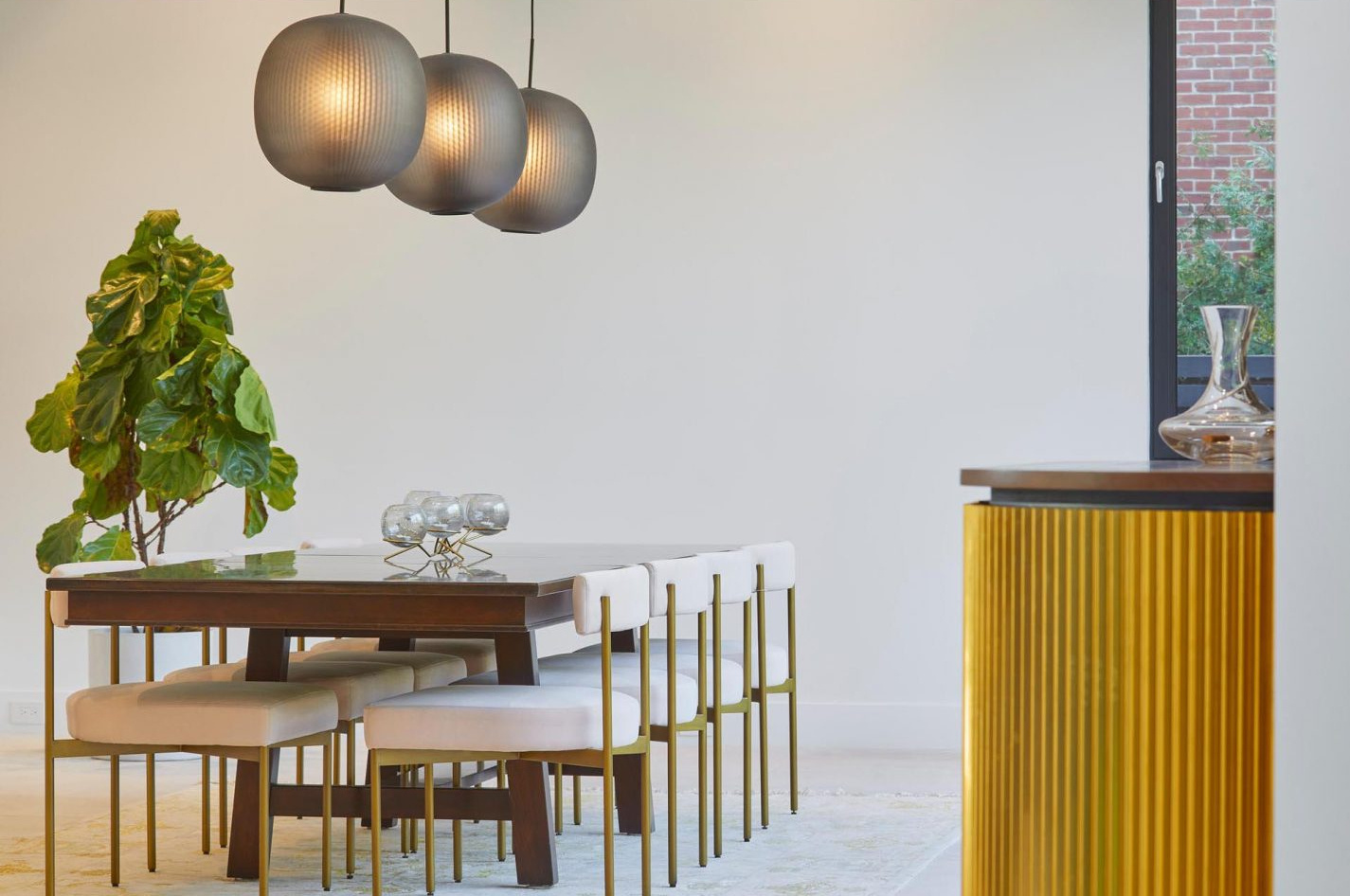 An open-plan kitchen and dining space with dual dining areas and seamless indoor-outdoor flooring.