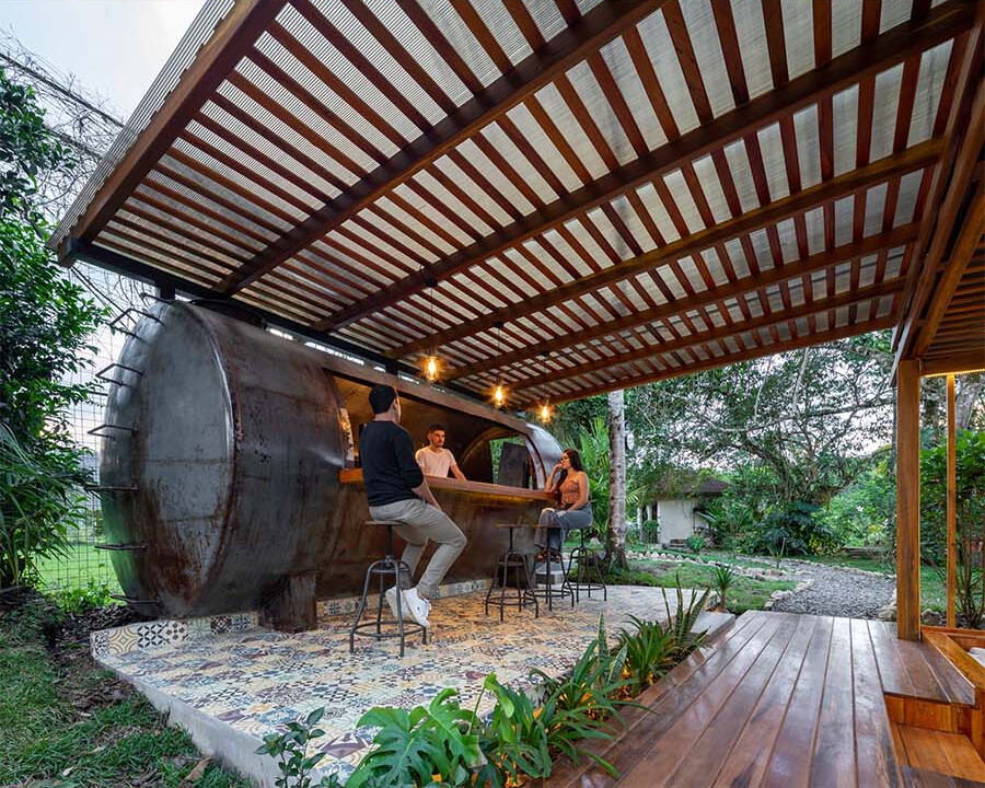 An old water tank is reimagined as a backyard bar, keeping its rustic exterior while adding modern function inside.