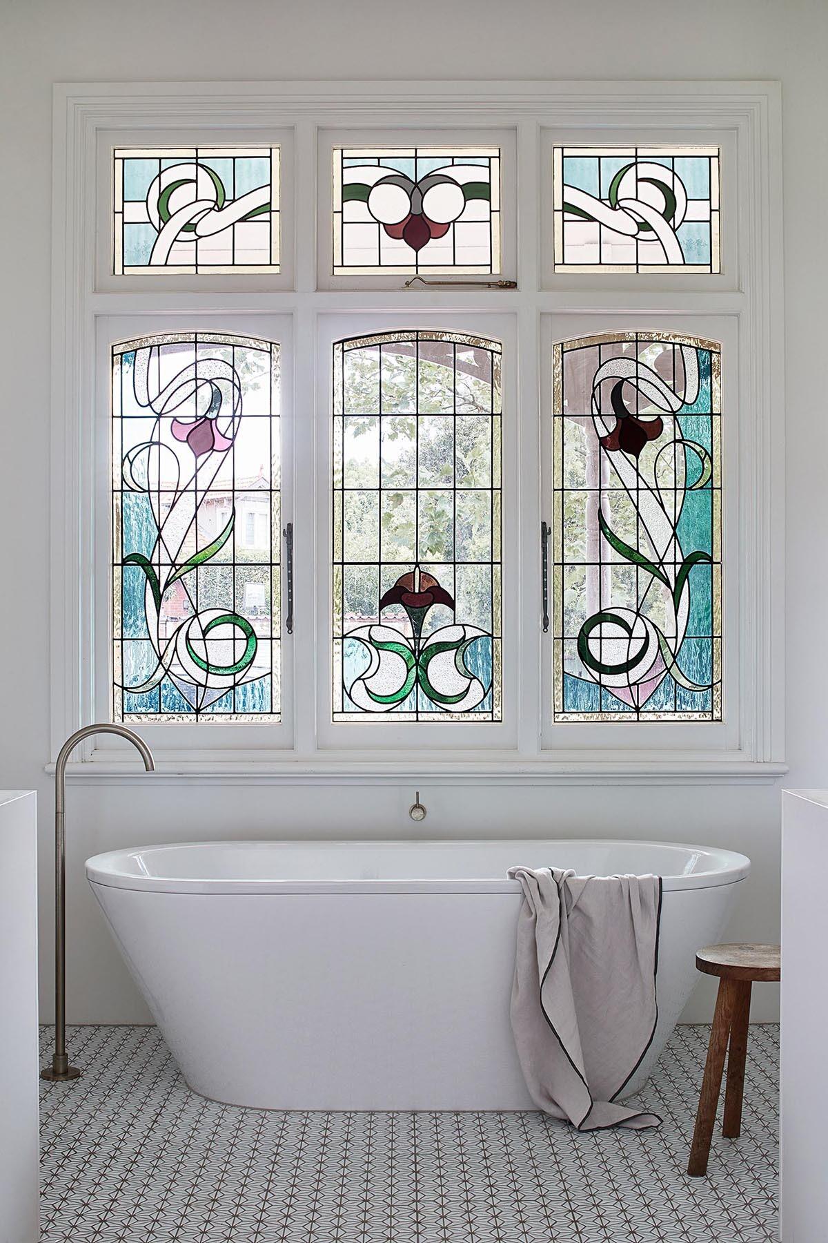 Stained glass details in the bathroom add color and continuity, linking new spaces to the home’s heritage.