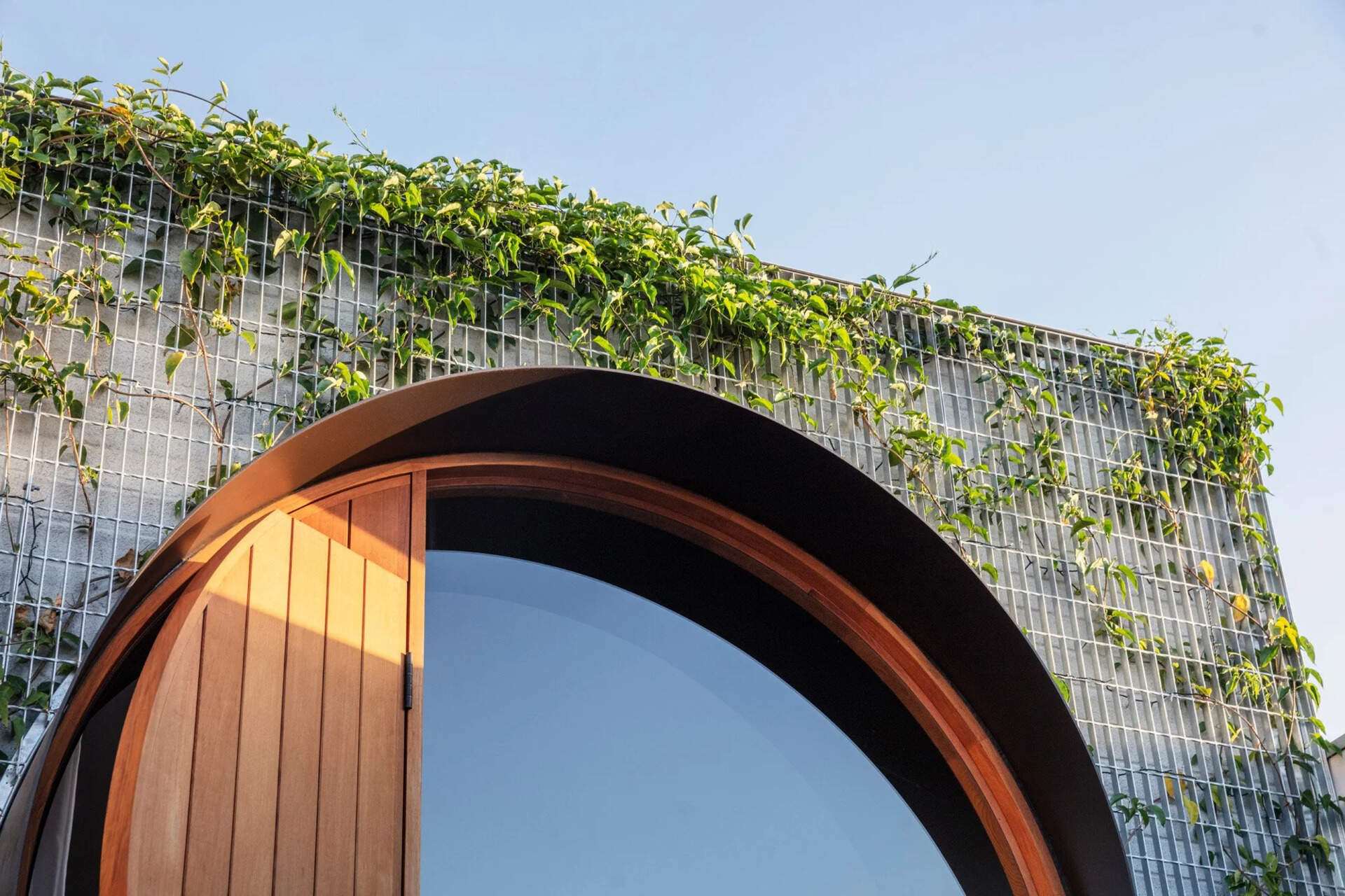 El pintoresco jardín, cubierto de enredaderas, está diseñado para enmarcar las ventanas redondas y brillar suavemente por la noche.