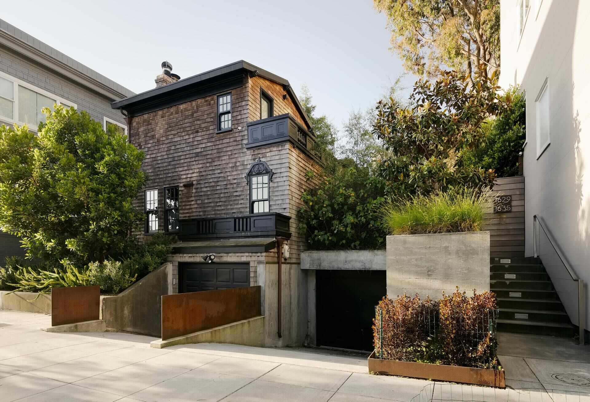 A restored 1917 facade in San Francisco featuring cedar shakes, black detailing, and heritage windows with subtle modern upgrades.