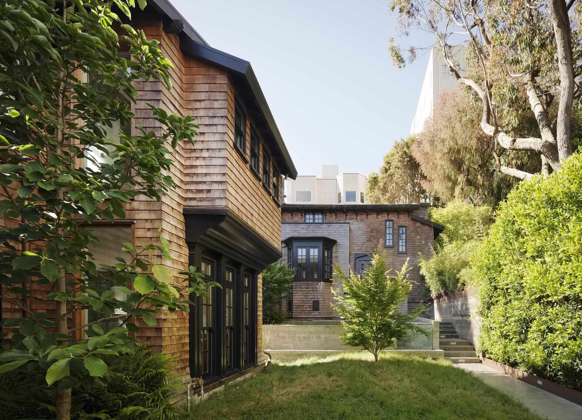 A restored 1917 facade in San Francisco featuring cedar shakes, black detailing, and heritage windows with subtle modern upgrades.