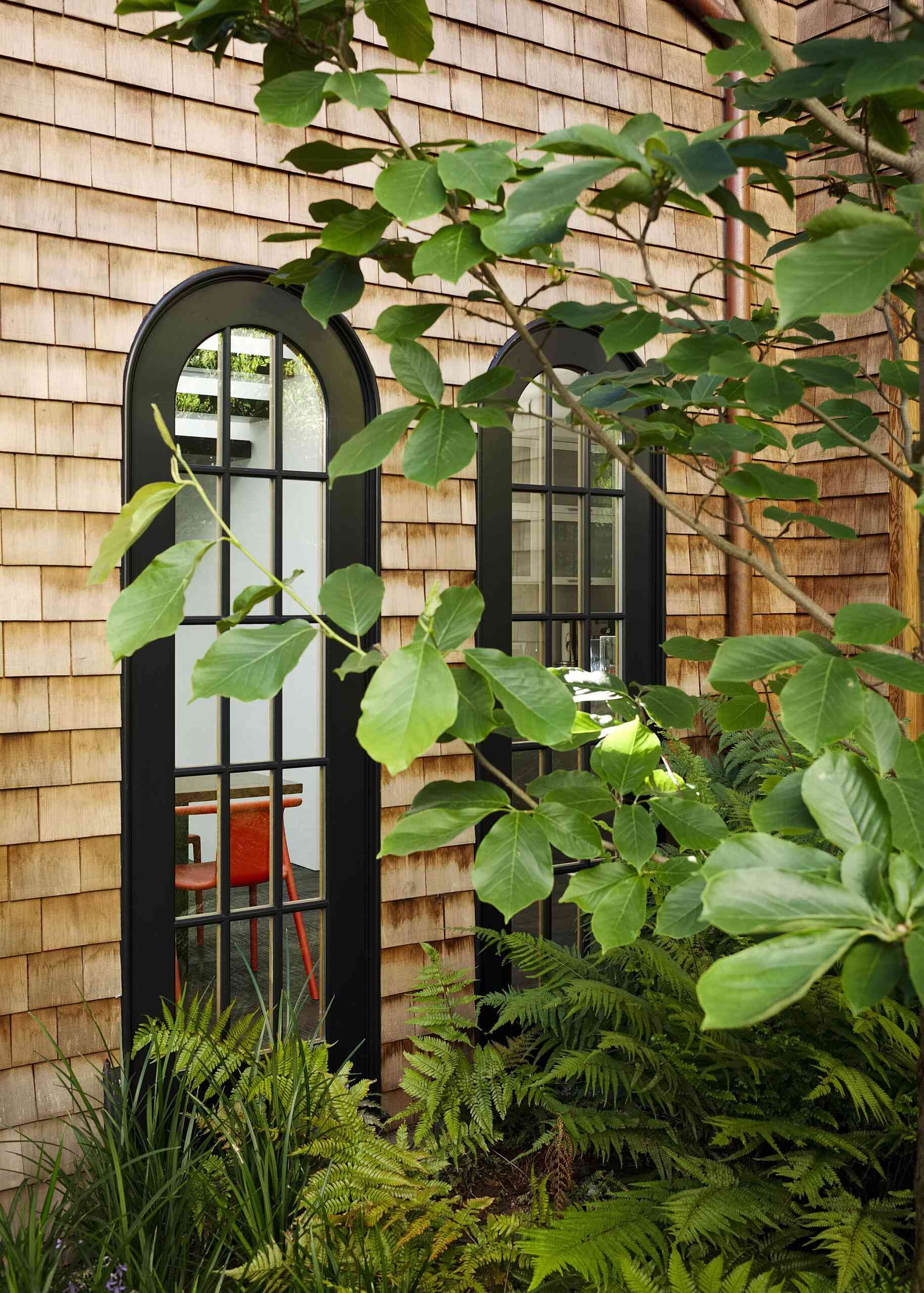 A restored 1917 facade in San Francisco featuring cedar shakes, black detailing, and heritage windows with subtle modern upgrades.