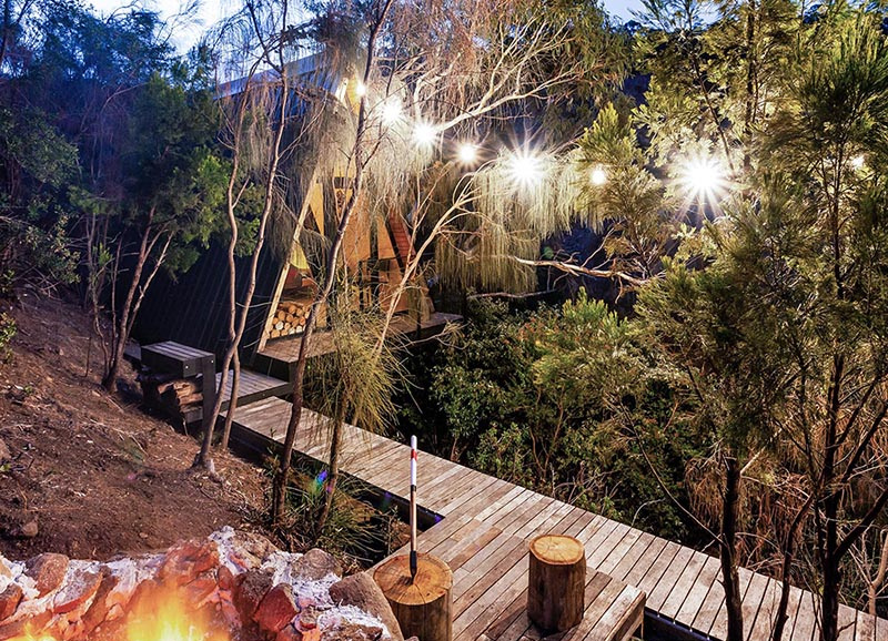 This A-frame cabin uses recycled materials like timber offcuts, old doors, and metal roofing to create a resourceful and character-filled design.