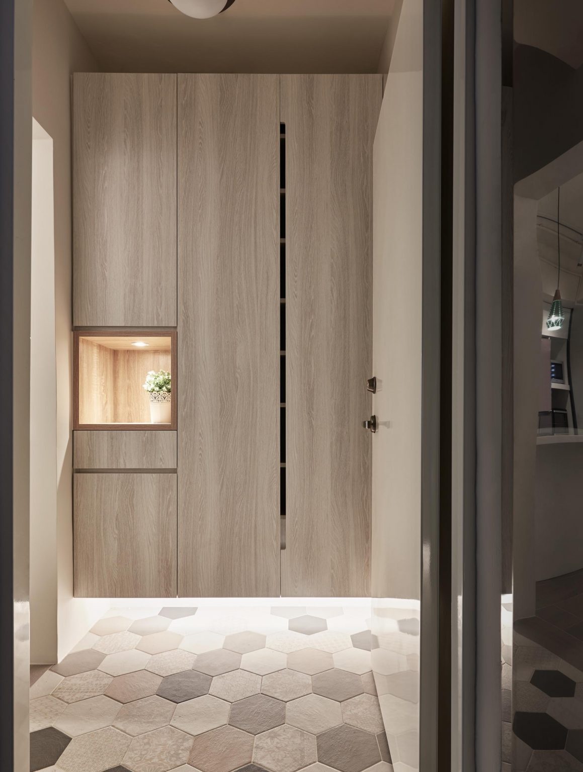 A minimalist entryway with floating storage, hidden LED lighting, and a small illuminated shelf for everyday essentials.