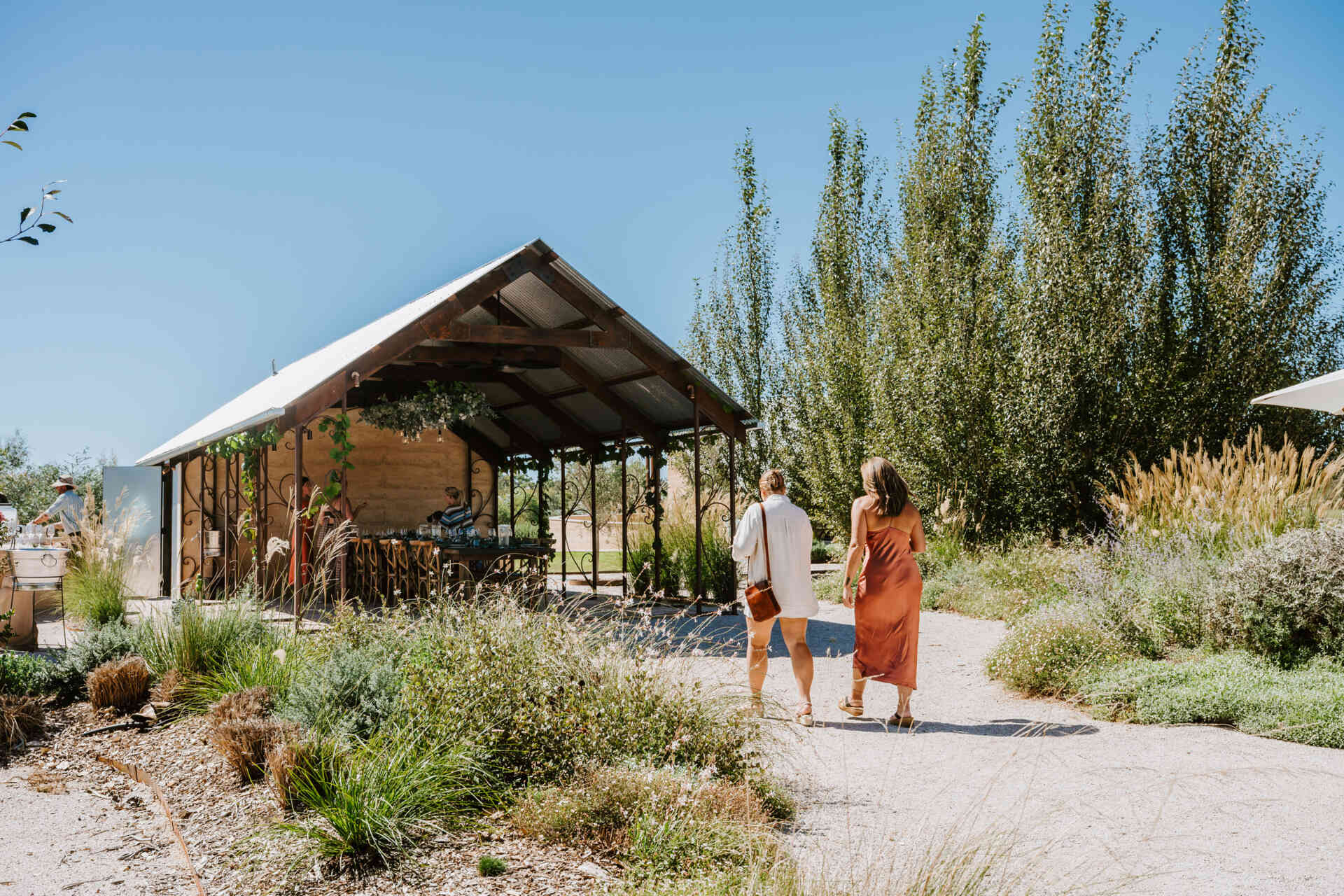 An intimate open-air events space in Australia where rammed earth, timber, and fire create a relaxed setting for gatherings and long-table dining.