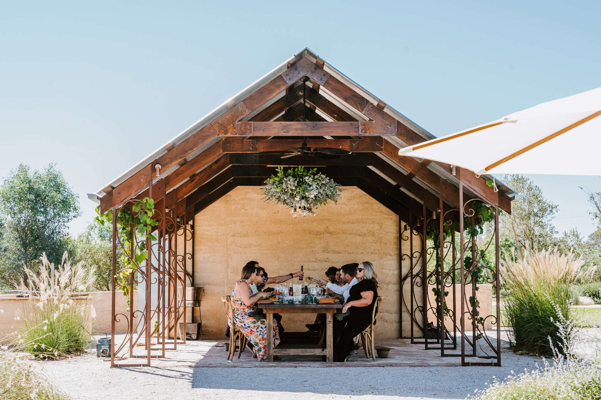 An intimate open-air events space in Australia where rammed earth, timber, and fire create a relaxed setting for gatherings and long-table dining.