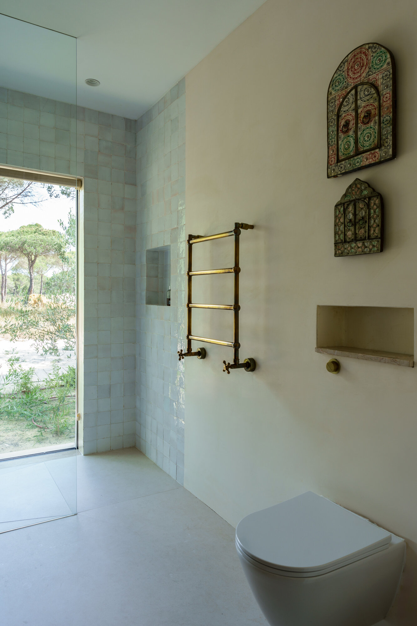 Minimalist bathrooms filled with filtered sunlight and natural textures continue the calm architectural language of this contemporary Portuguese villa.