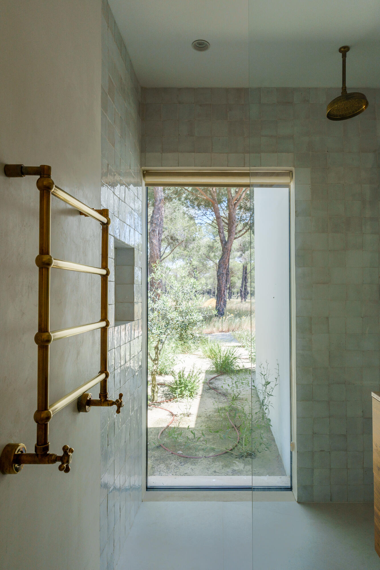 Minimalist bathrooms filled with filtered sunlight and natural textures continue the calm architectural language of this contemporary Portuguese villa.