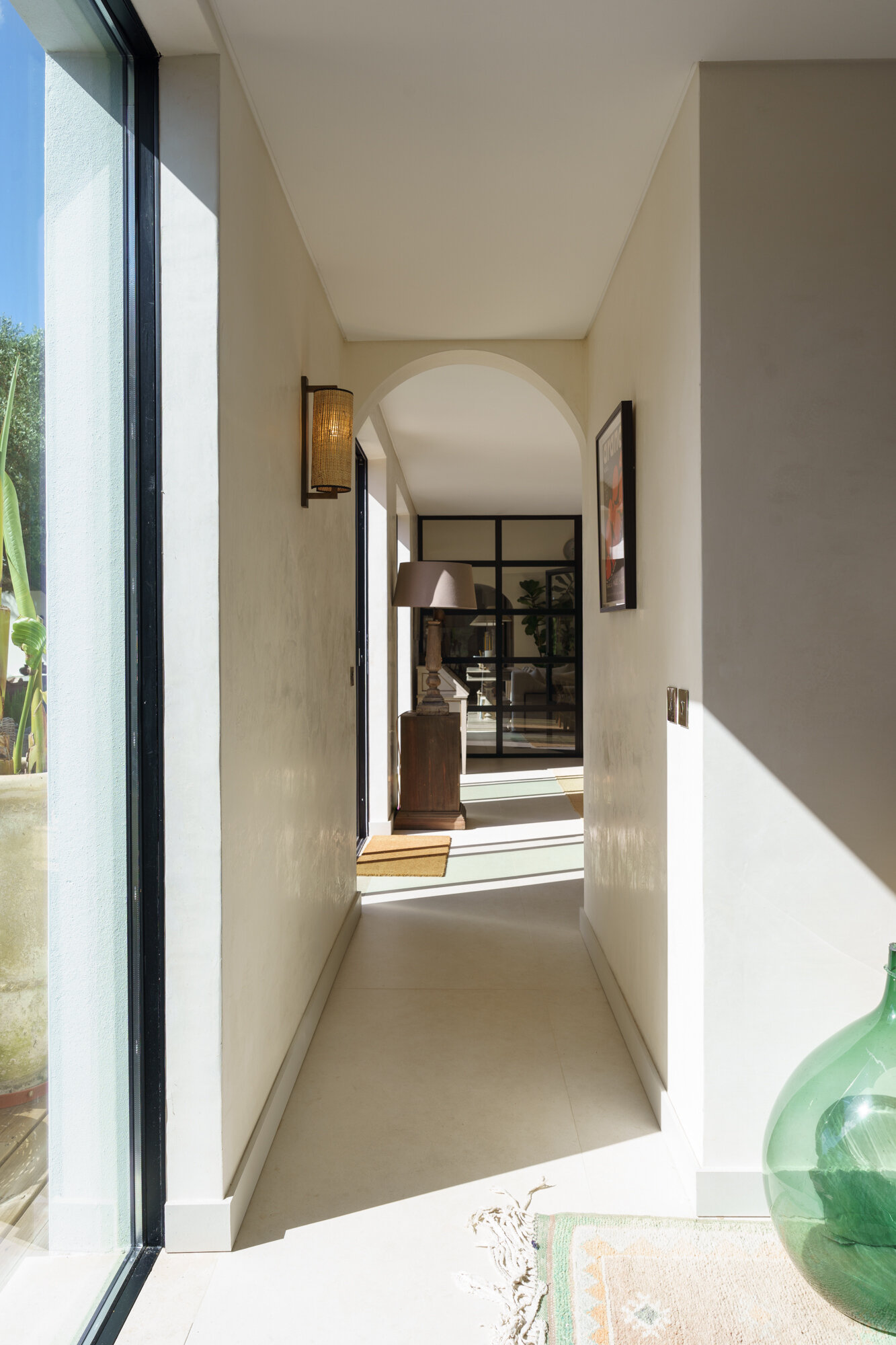 Minimalist hallways lined with filtered sunlight and framed forest views turn circulation spaces into one of the most atmospheric features of this Comporta villa.
