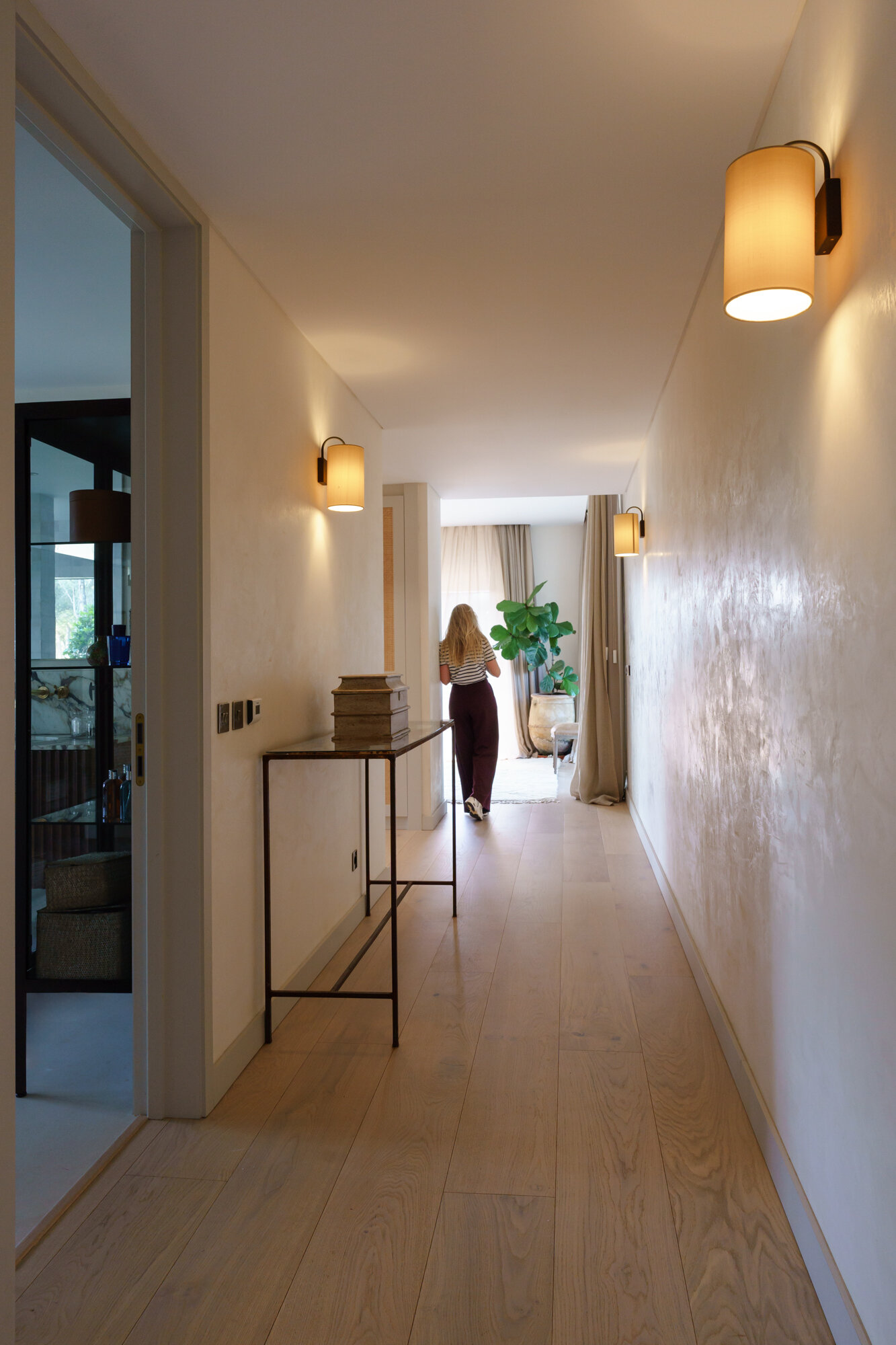 Minimalist hallways lined with filtered sunlight and framed forest views turn circulation spaces into one of the most atmospheric features of this Comporta villa.