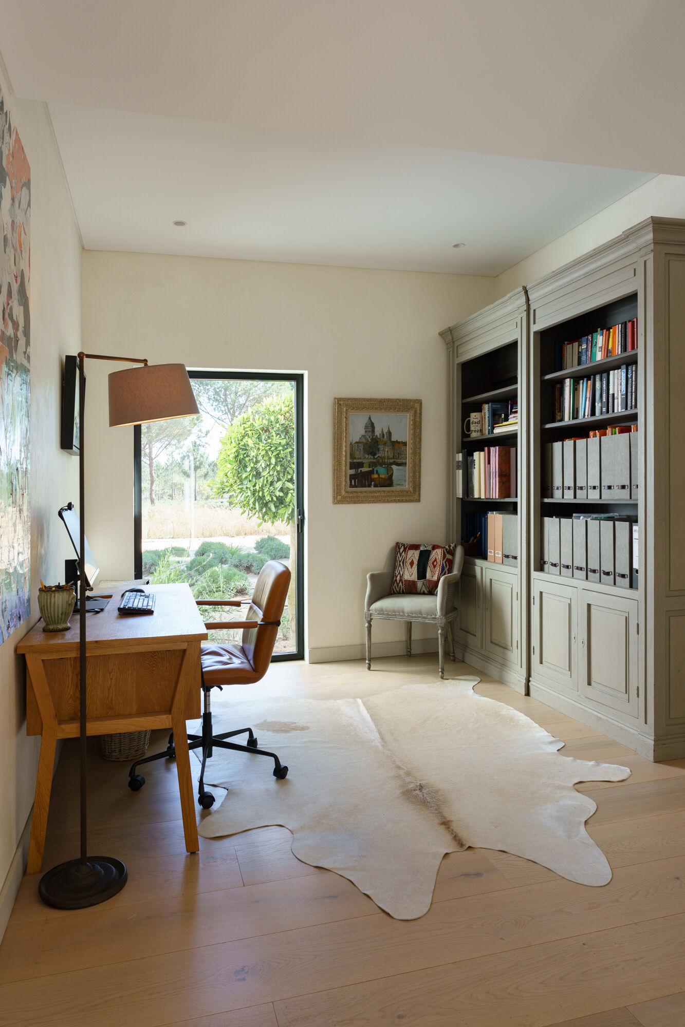 This modern home office overlooks the pine forests of Comporta through a glass door, creating a bright workspace immersed in nature.
