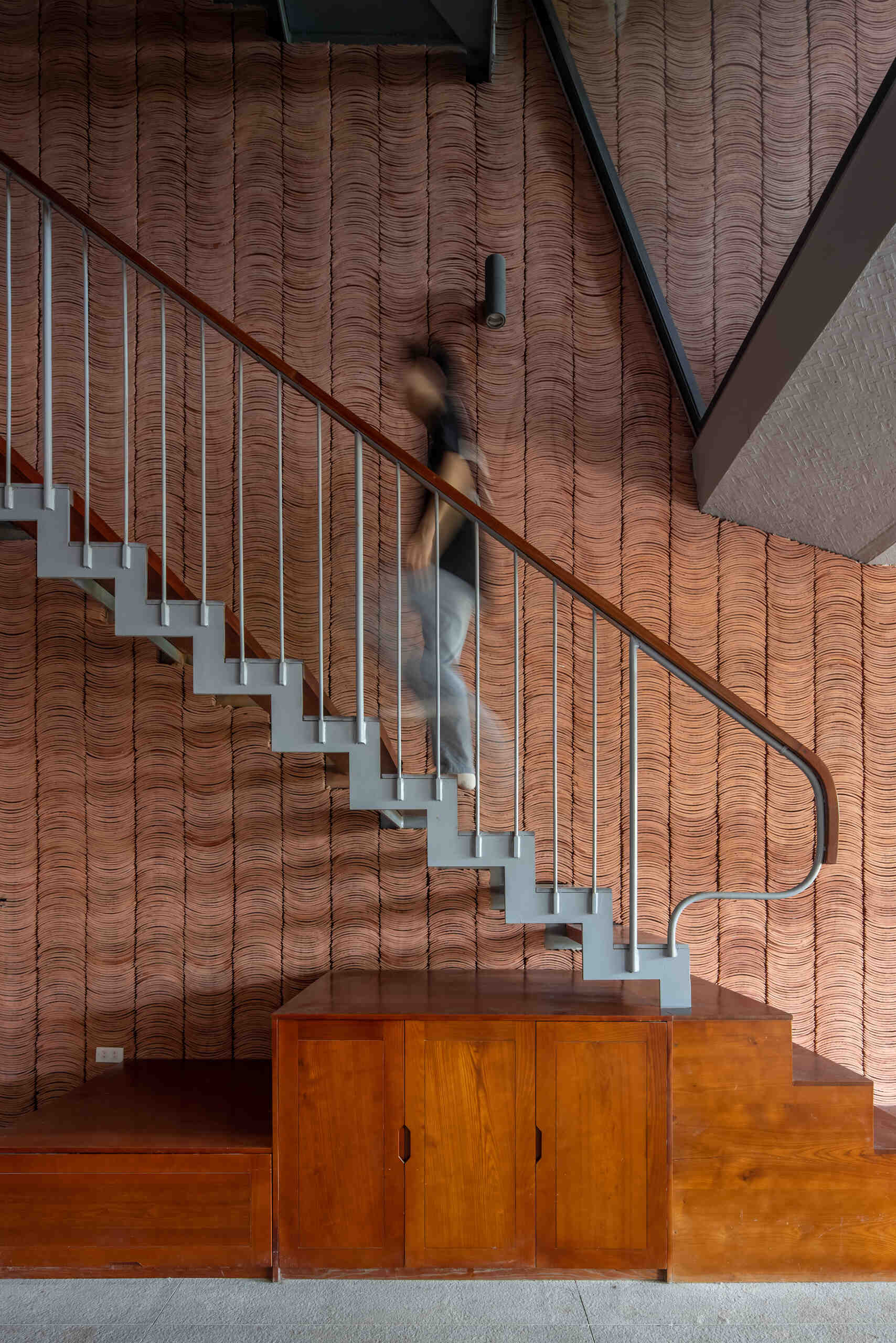 The staircase offers changing views of greenery and light as it connects each level.