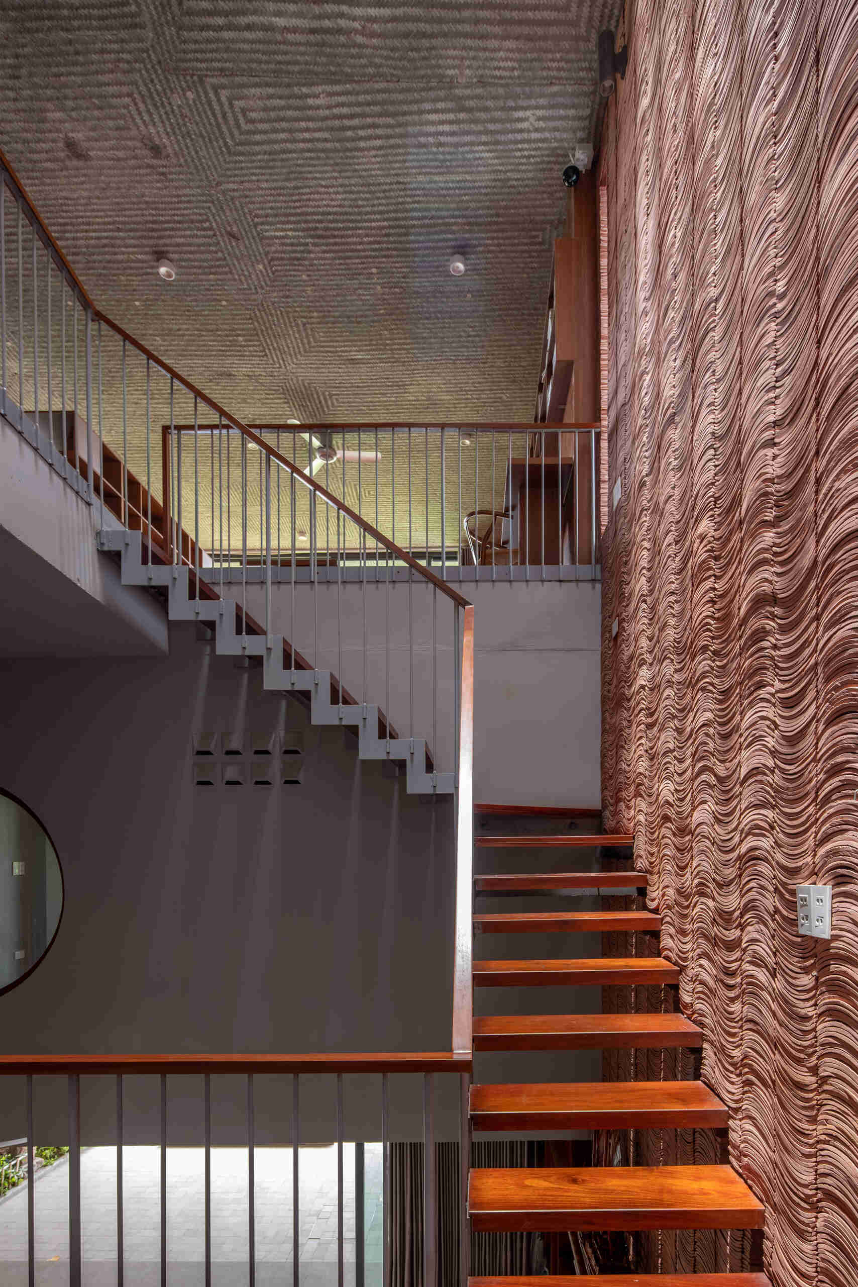The staircase offers changing views of greenery and light as it connects each level.