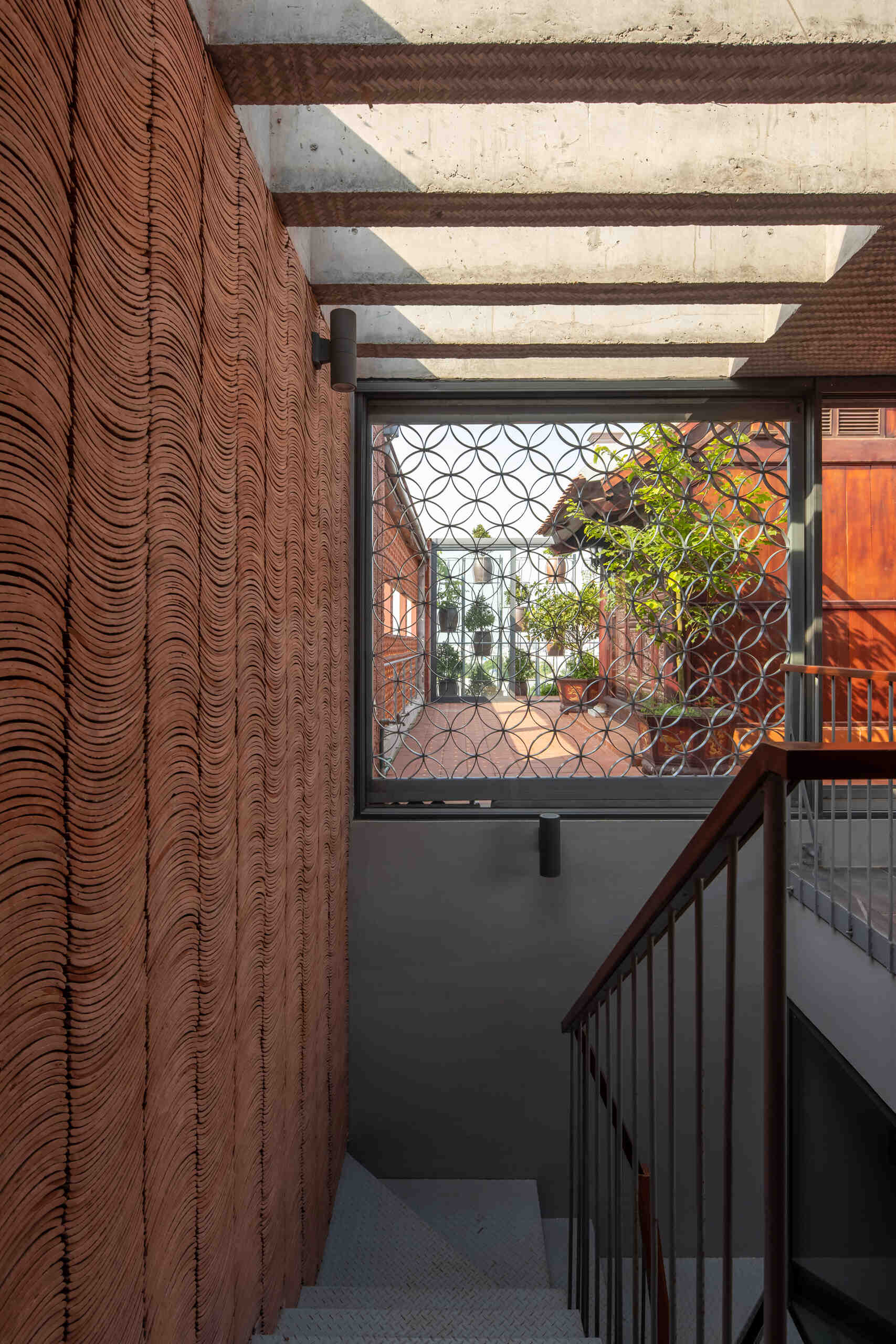 The staircase offers changing views of greenery and light as it connects each level.