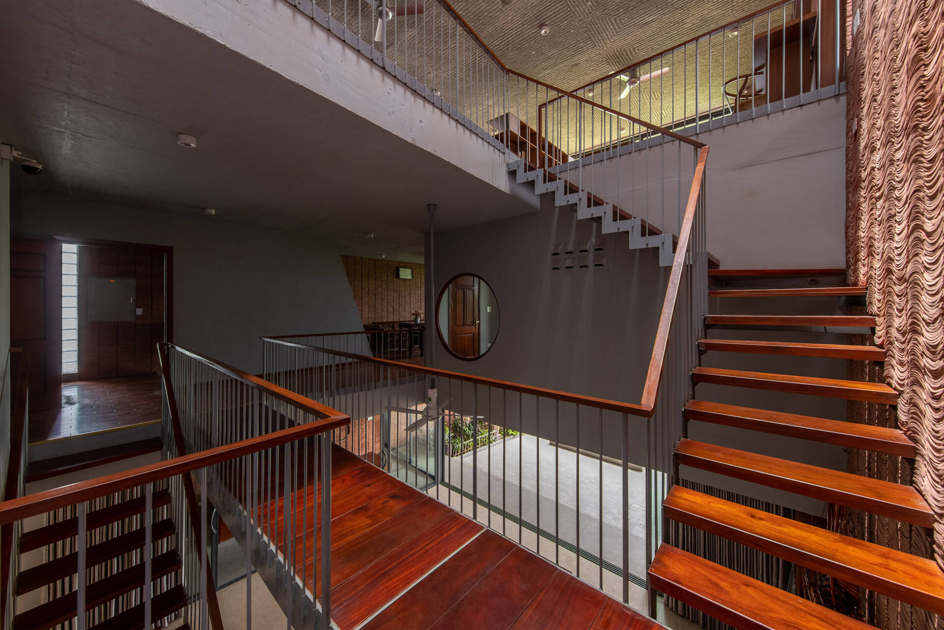 The staircase offers changing views of greenery and light as it connects each level.