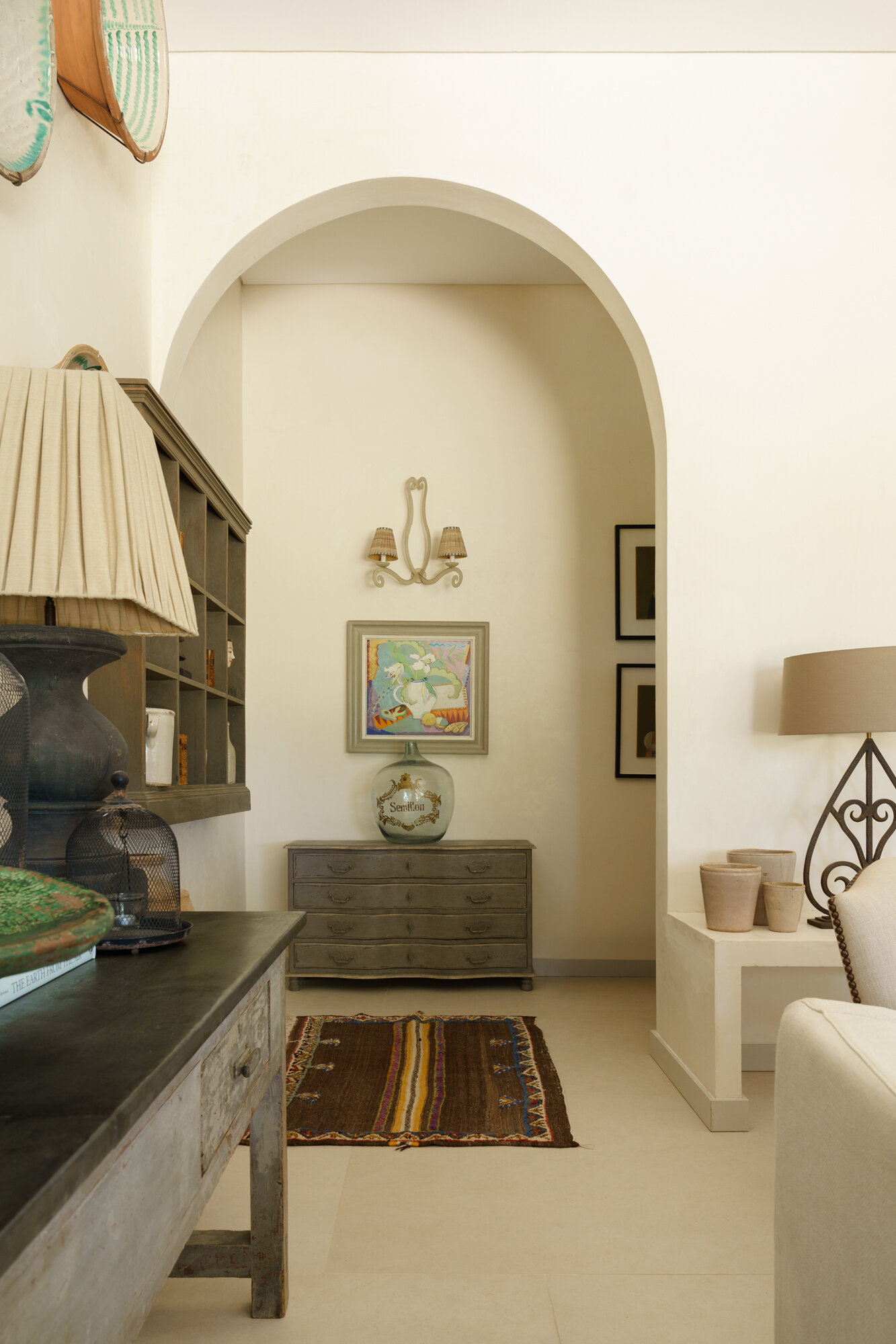 Inside the central wing of the villa, the living room opens completely toward the courtyard through expansive retractable glazing. The room feels constantly linked to the outdoors. Even when closed, the glass walls maintain uninterrupted views of trees, sand, and sky from nearly every angle.