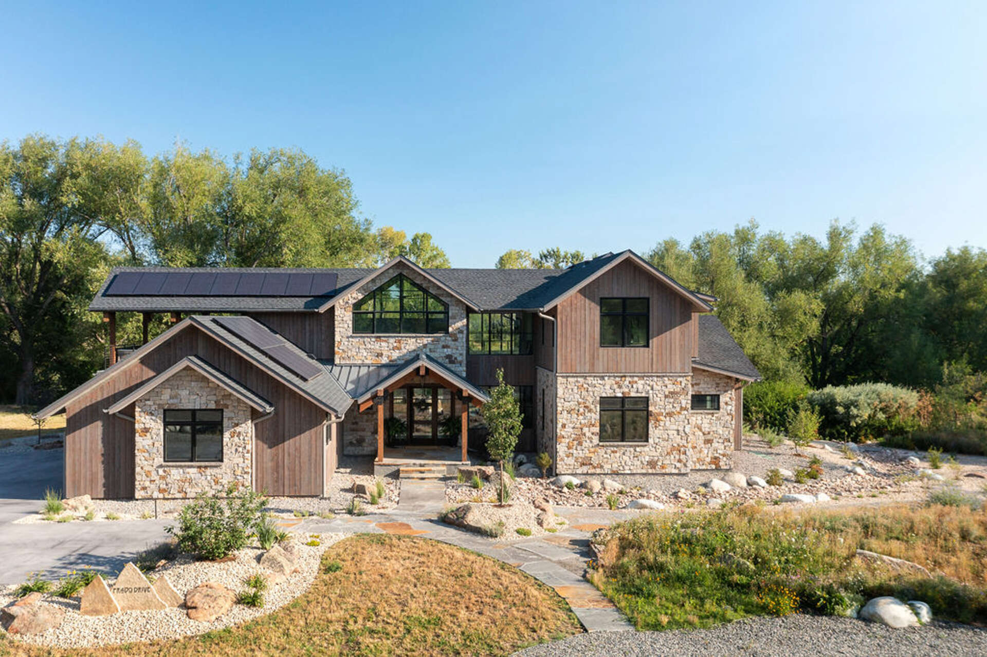 A modern mountain home in Boulder, Colorado combines timber, stone, and walls of glass to frame Flatirons views beside South Boulder Creek.