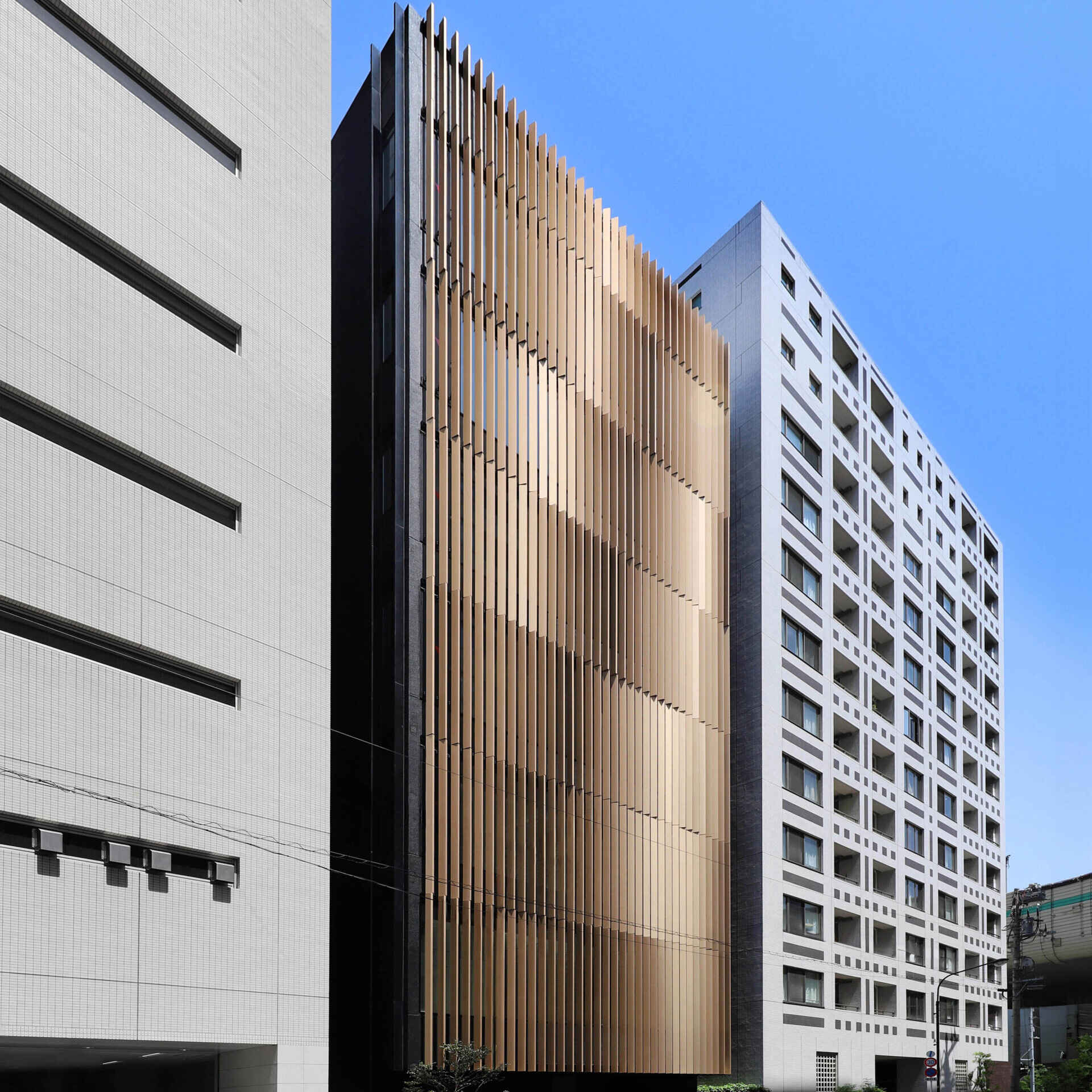 The inspiration for this building is wheat, with the facade reads as a wheat field swaying in a "wind of memory" across Nihonbashi. Louver rhythm and gentle undulation were refined through computational studies so invisible forces-wind, time, and fermentation-can be felt as geometry, light, and shadow, while also delivering real shading and privacy.