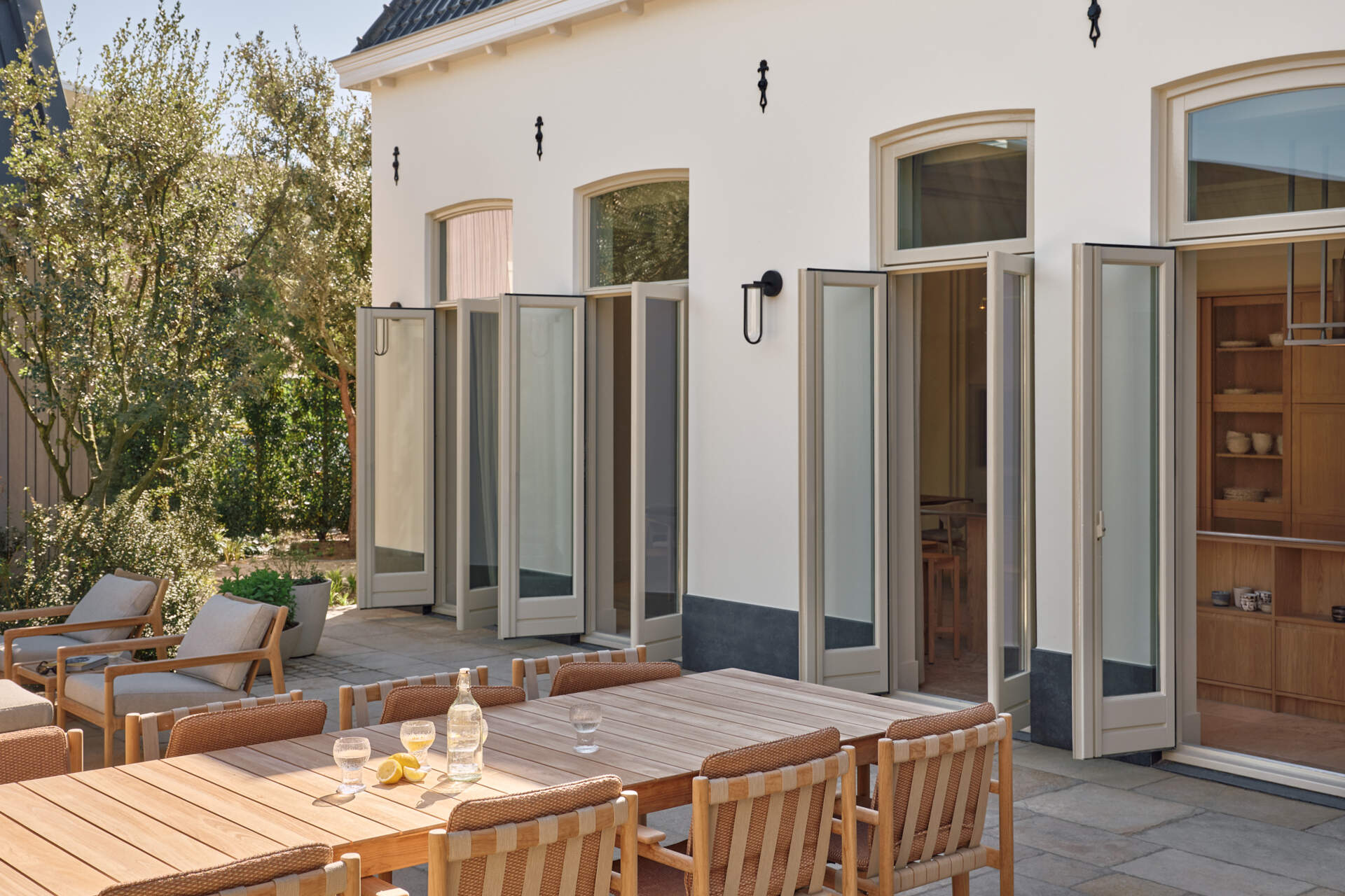 This landscaped riverside garden features outdoor dining zones, light furniture, and beautiful views stretching across the Rijn.