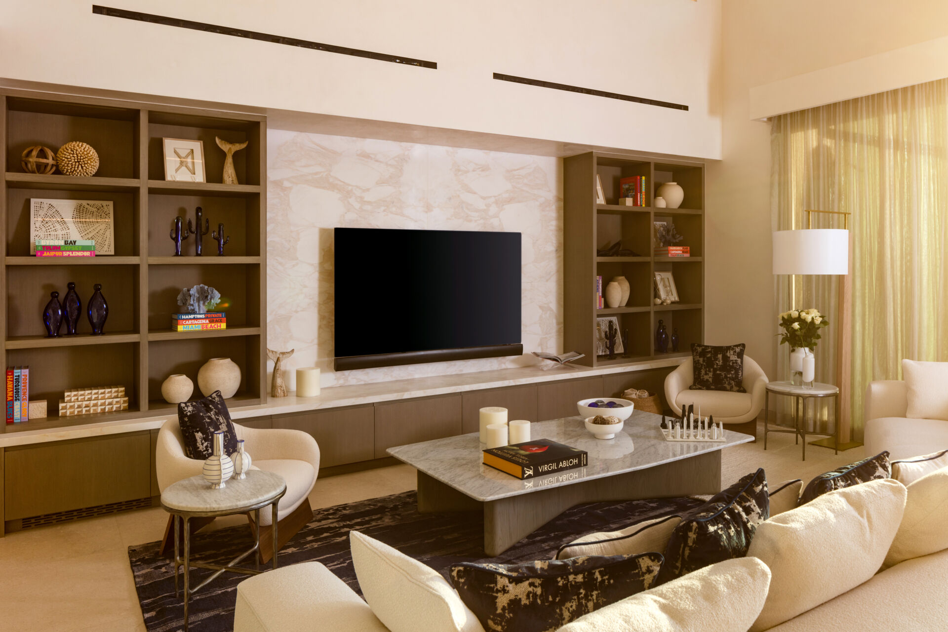 The living room in this Los Cabos condo combines ocean views, layered woods, and relaxed seating designed for family gatherings.