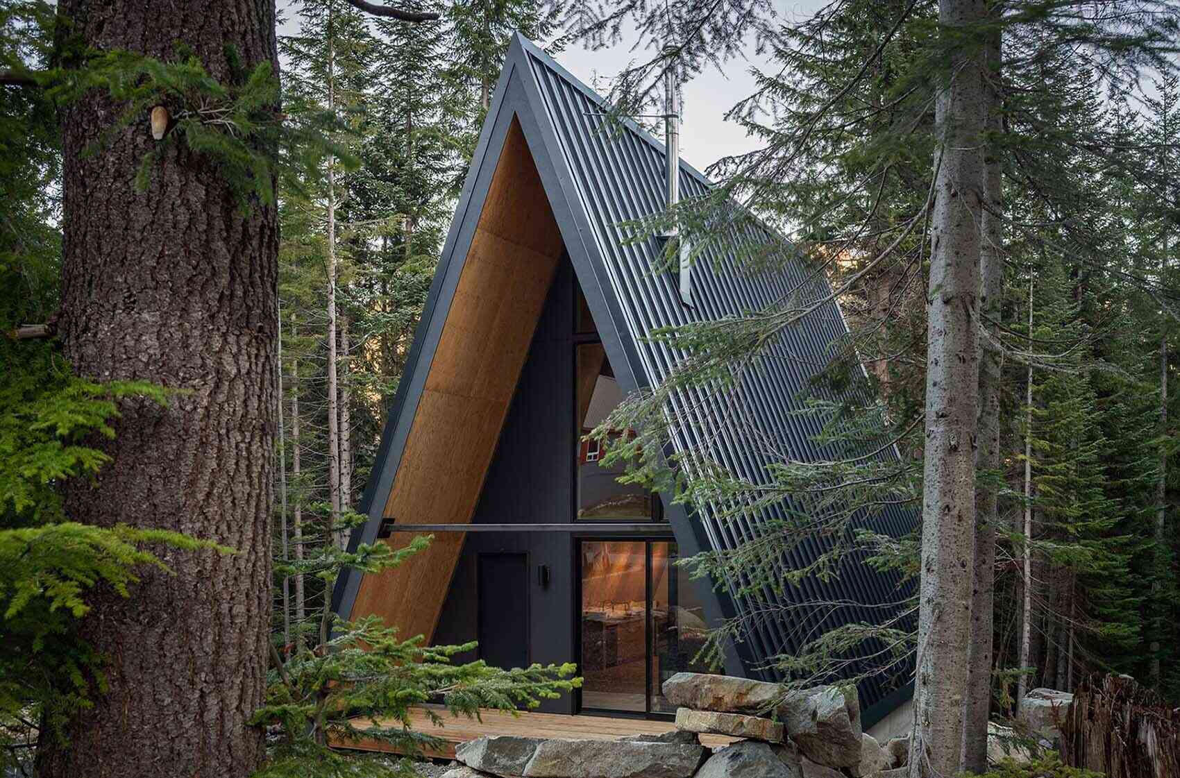 Prefab plywood panels and a black standing-seam metal roof give this Washington mountain A-frame cabin a sleek modern look built to handle heavy winter snow.
