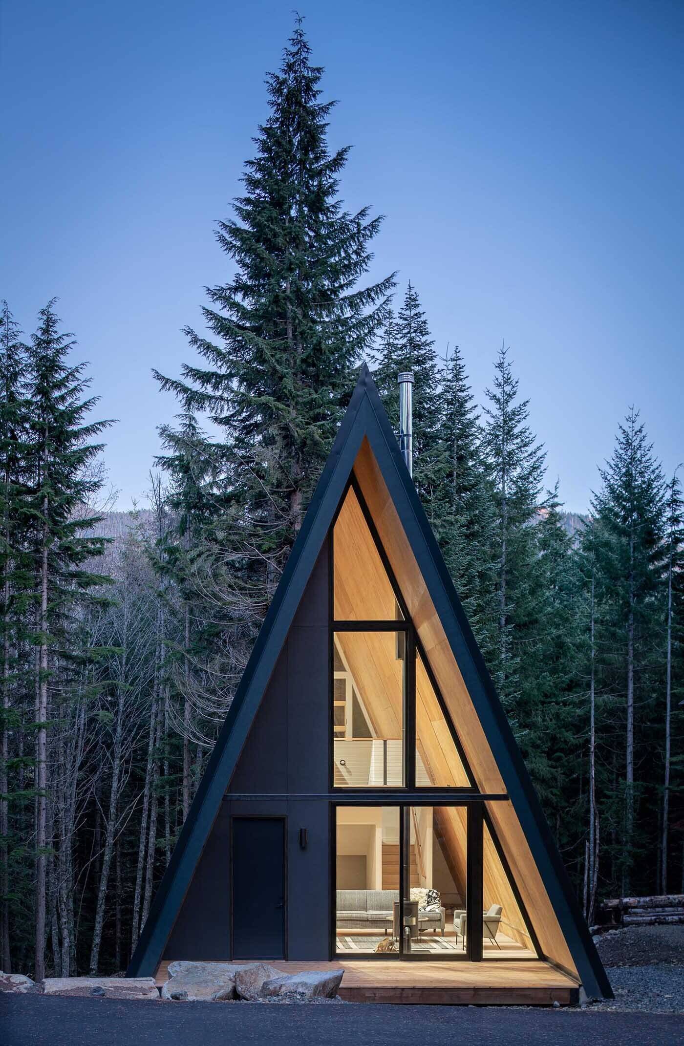 Prefab plywood panels and a black standing-seam metal roof give this Washington mountain A-frame cabin a sleek modern look built to handle heavy winter snow.