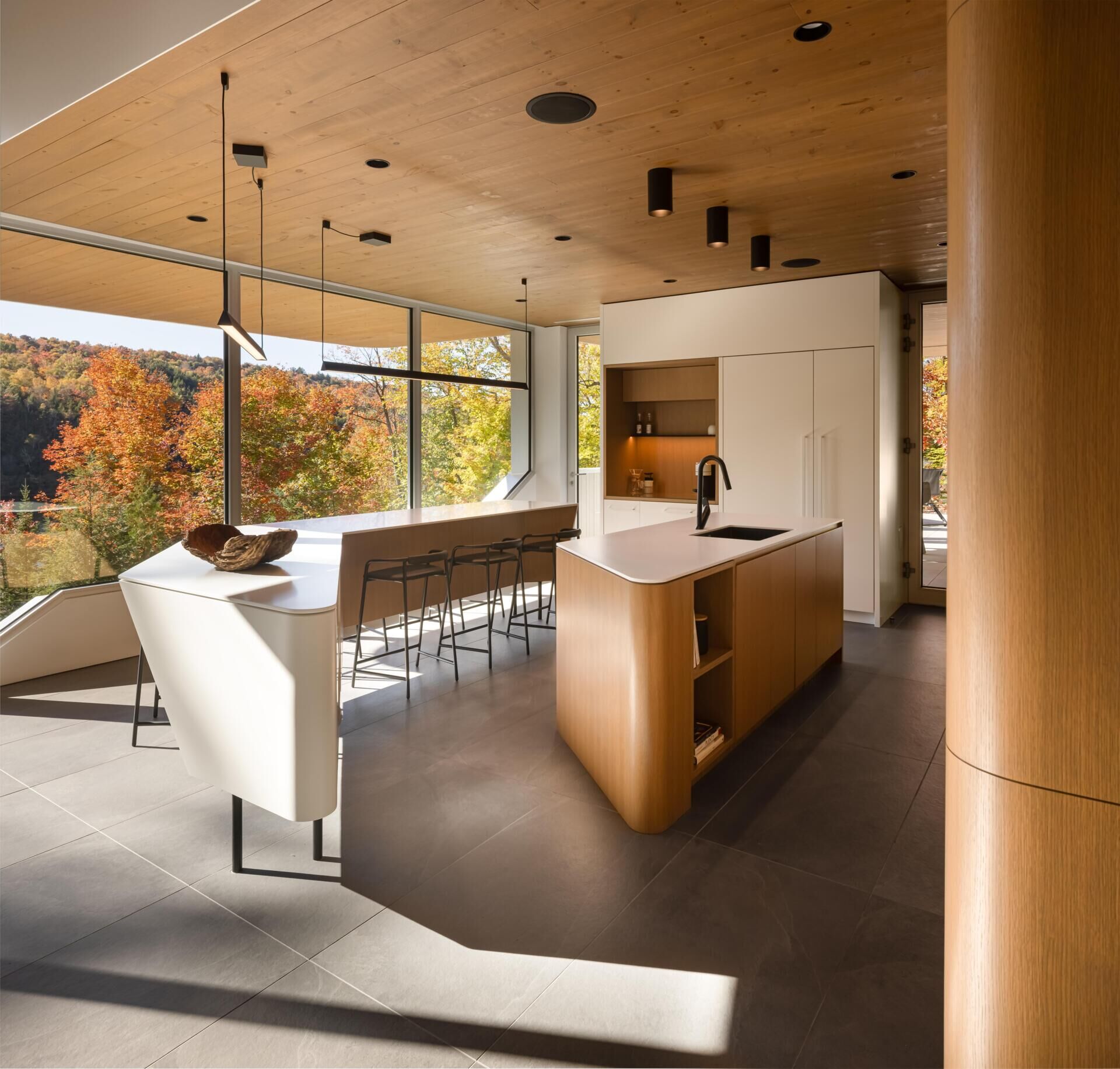 Two sculptural kitchen islands and sunset lake views turn this contemporary Québec kitchen into a standout entertaining space.