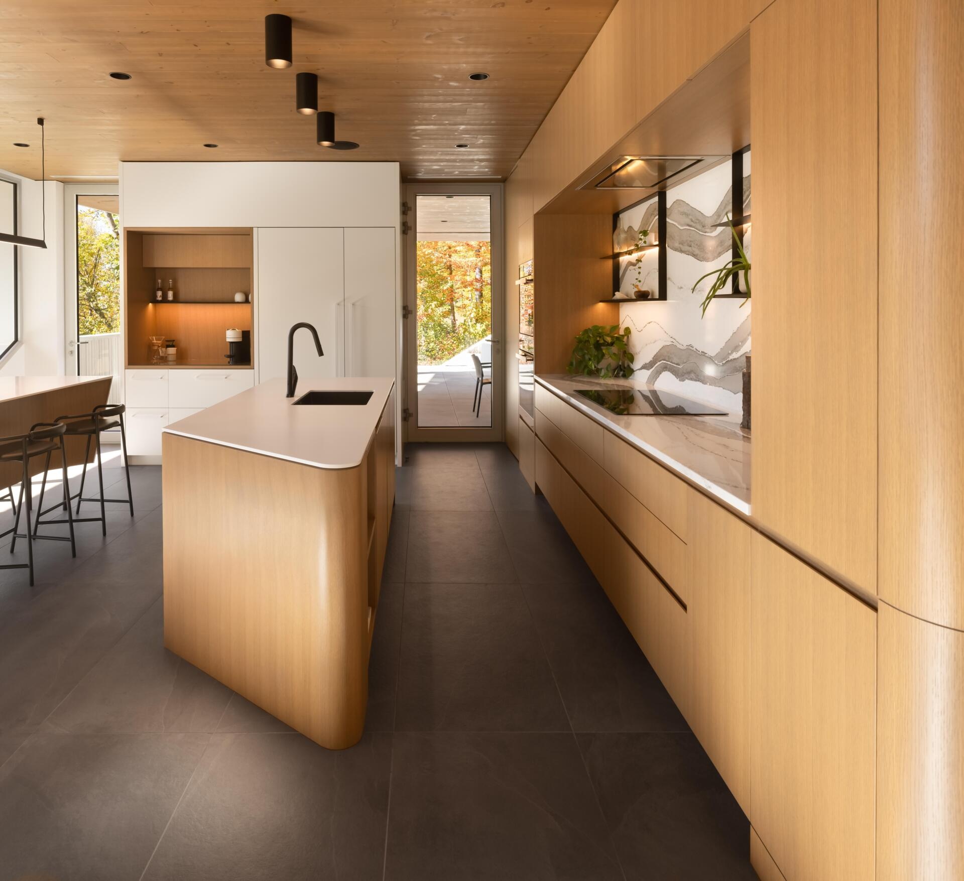 Two sculptural kitchen islands and sunset lake views turn this contemporary Québec kitchen into a standout entertaining space.