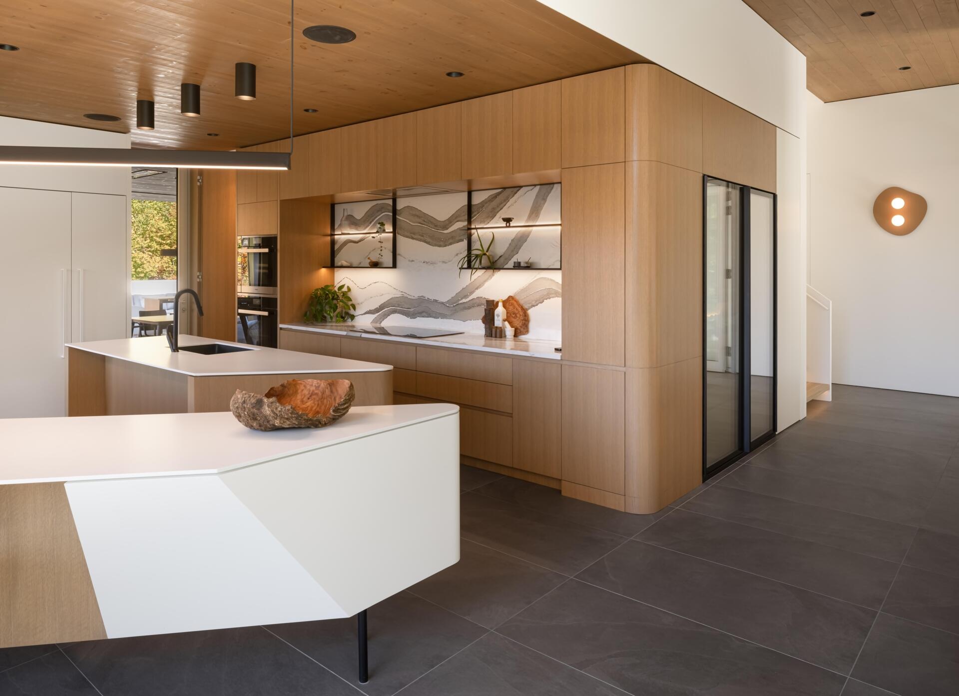 Two sculptural kitchen islands and sunset lake views turn this contemporary Québec kitchen into a standout entertaining space.