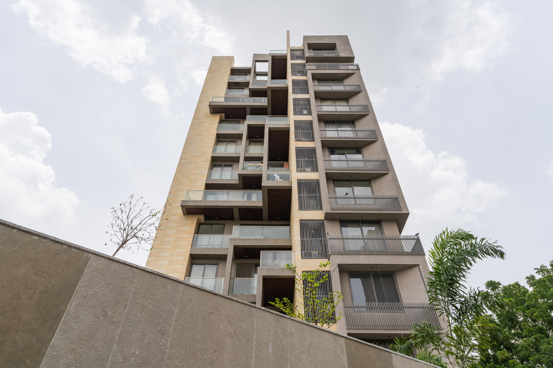 This Ahmedabad apartment building by UA Lab uses staggered balconies and deep overhangs to create a playful facade designed for light, airflow, and shade.