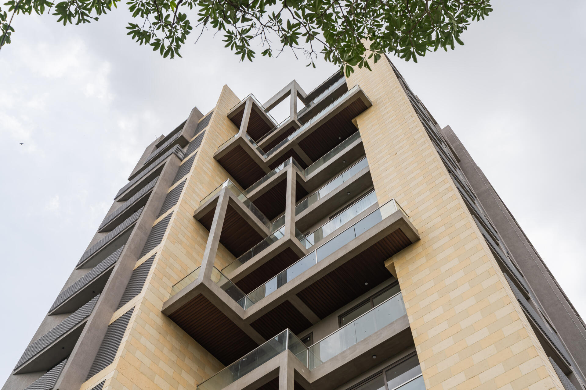 This Ahmedabad apartment building by UA Lab uses staggered balconies and deep overhangs to create a playful facade designed for light, airflow, and shade.