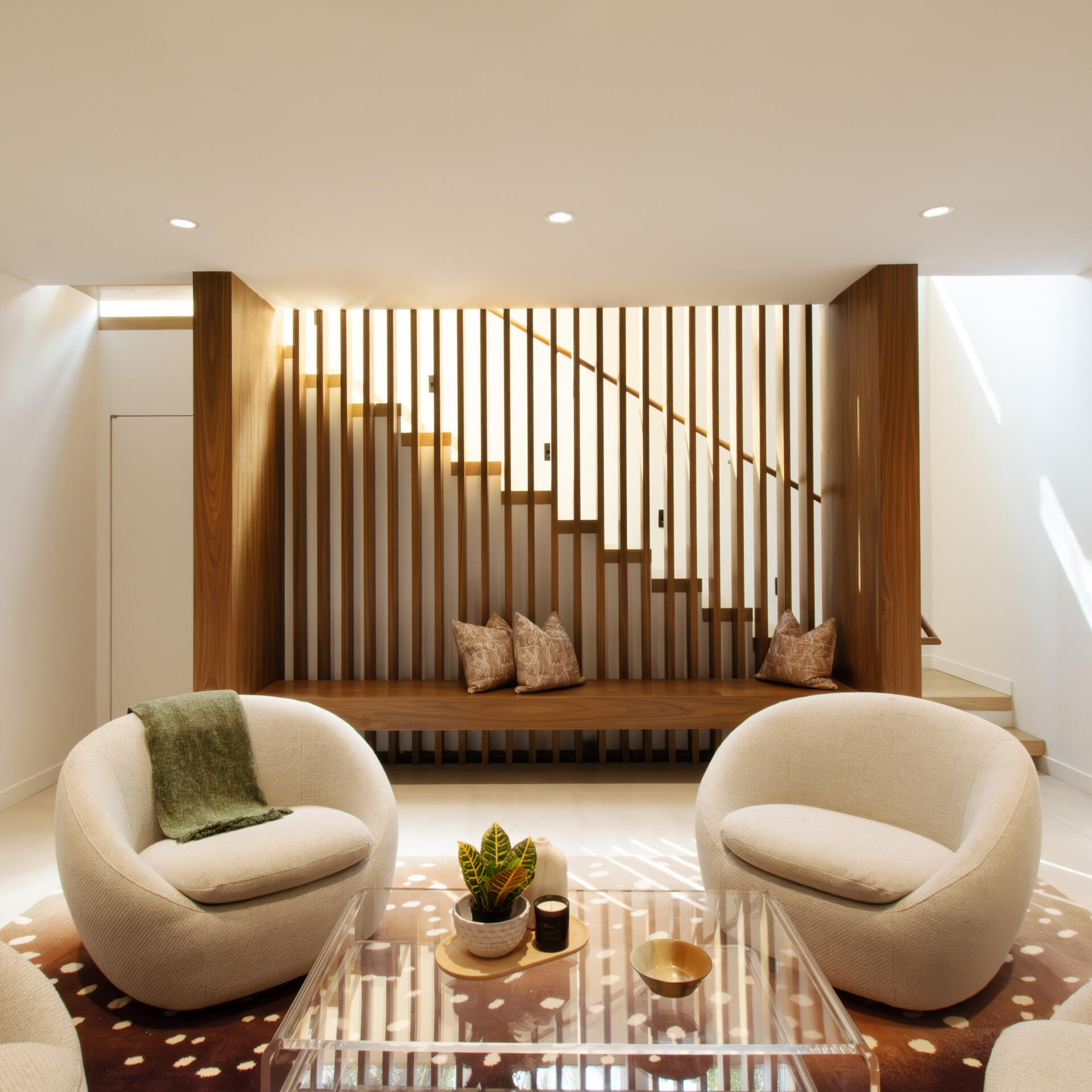 This relaxed basement lounge combines warm materials with flexible spaces for entertainment and downtime.