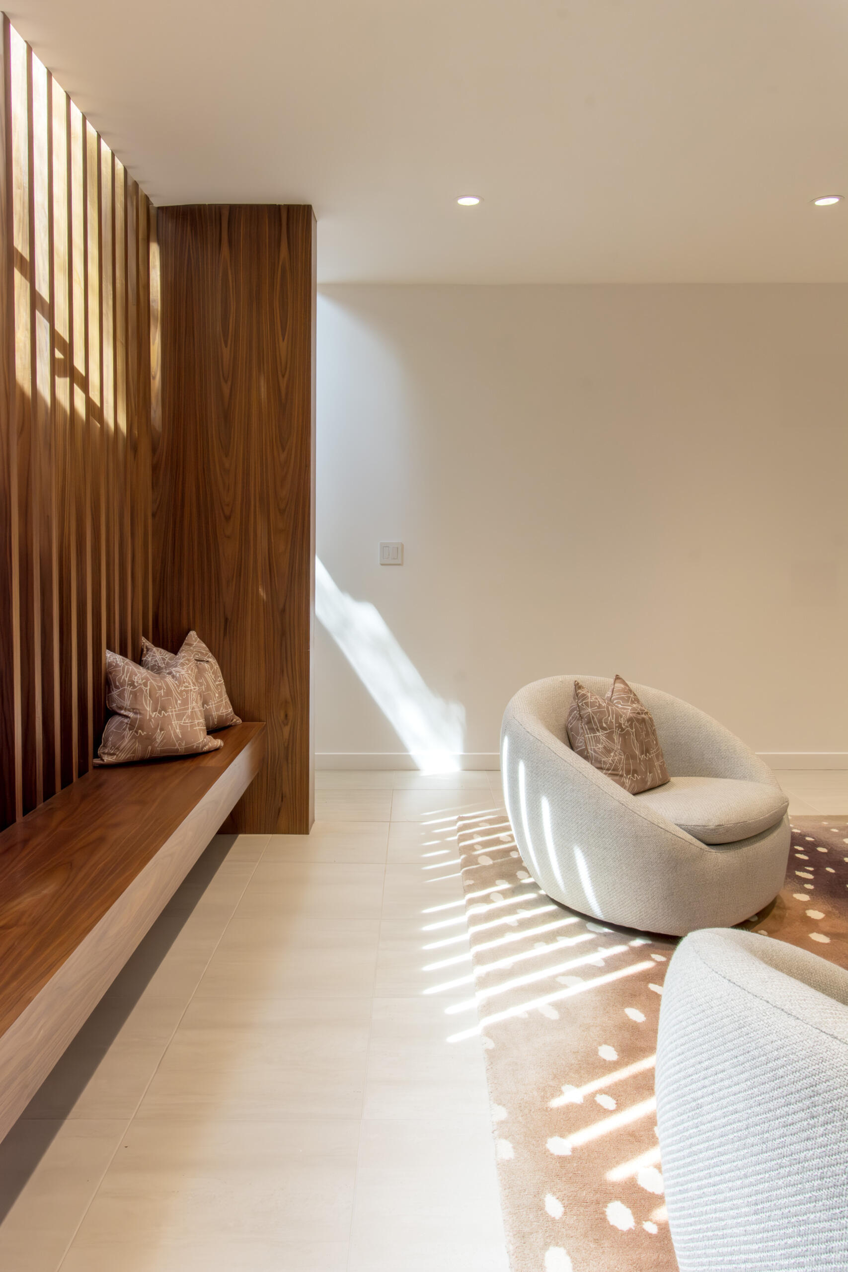 This relaxed basement lounge combines warm materials with flexible spaces for entertainment and downtime.