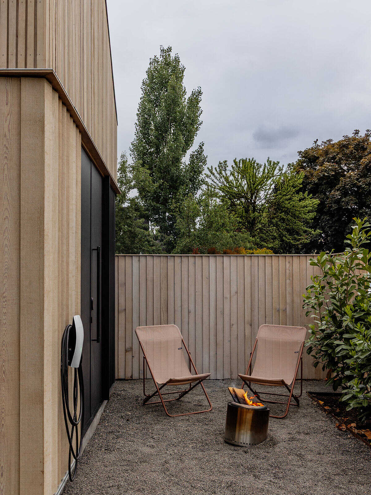 This cedar-clad bathhouse in Portland, Oregon transforms the footprint of a 100-year-old carriage house into a striking modern backyard spa. Designed by Ment Architecture with landscape design by Planterra Design, the project combines custom cedar siding, black steel details, lush layered planting, bluestone patios, and moody garden spaces inspired by Portland’s rainy winters.