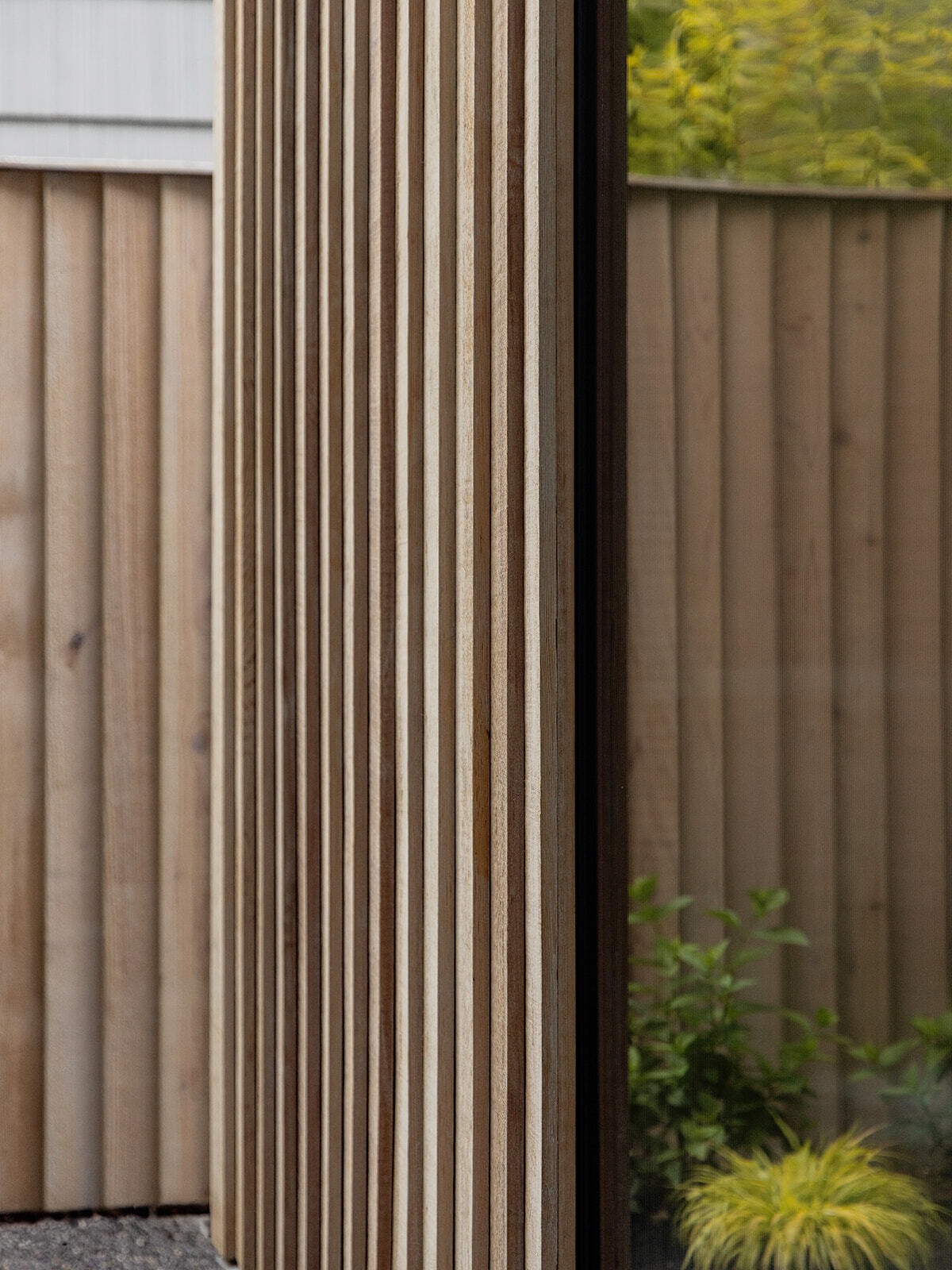 This cedar-clad bathhouse in Portland, Oregon transforms the footprint of a 100-year-old carriage house into a striking modern backyard spa. Designed by Ment Architecture with landscape design by Planterra Design, the project combines custom cedar siding, black steel details, lush layered planting, bluestone patios, and moody garden spaces inspired by Portland’s rainy winters.