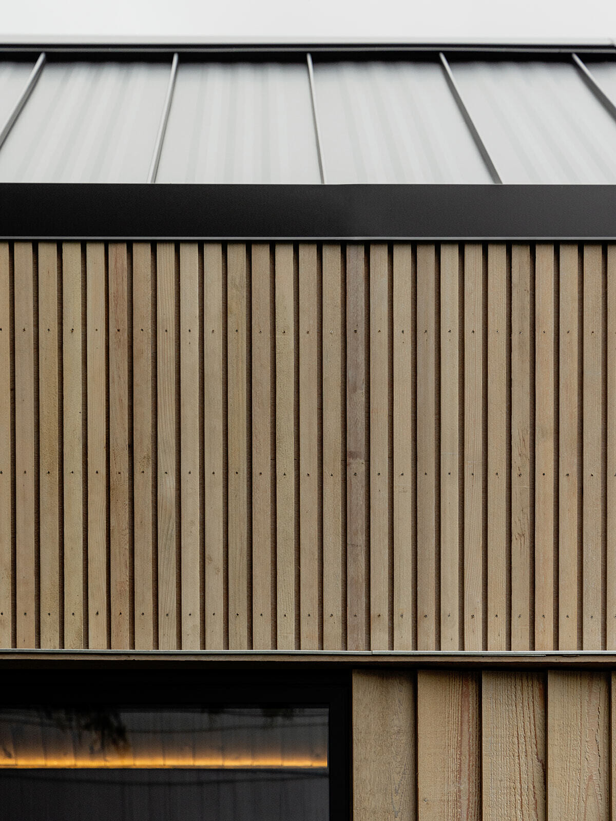 This cedar-clad bathhouse in Portland, Oregon transforms the footprint of a 100-year-old carriage house into a striking modern backyard spa. Designed by Ment Architecture with landscape design by Planterra Design, the project combines custom cedar siding, black steel details, lush layered planting, bluestone patios, and moody garden spaces inspired by Portland’s rainy winters.