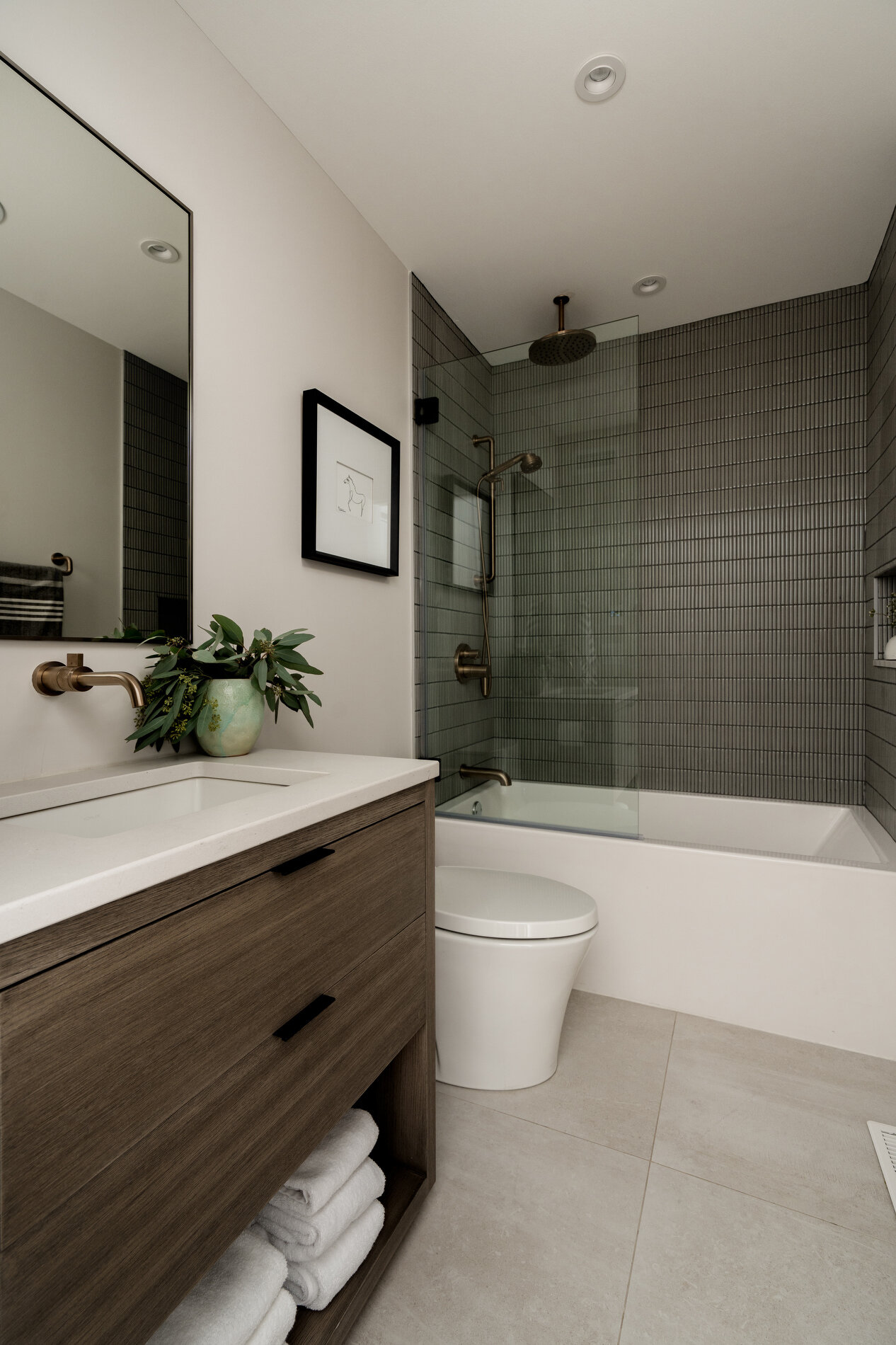 A modern bathroom with thin vertical 'kit-kat' style tiles and a shelving niche.