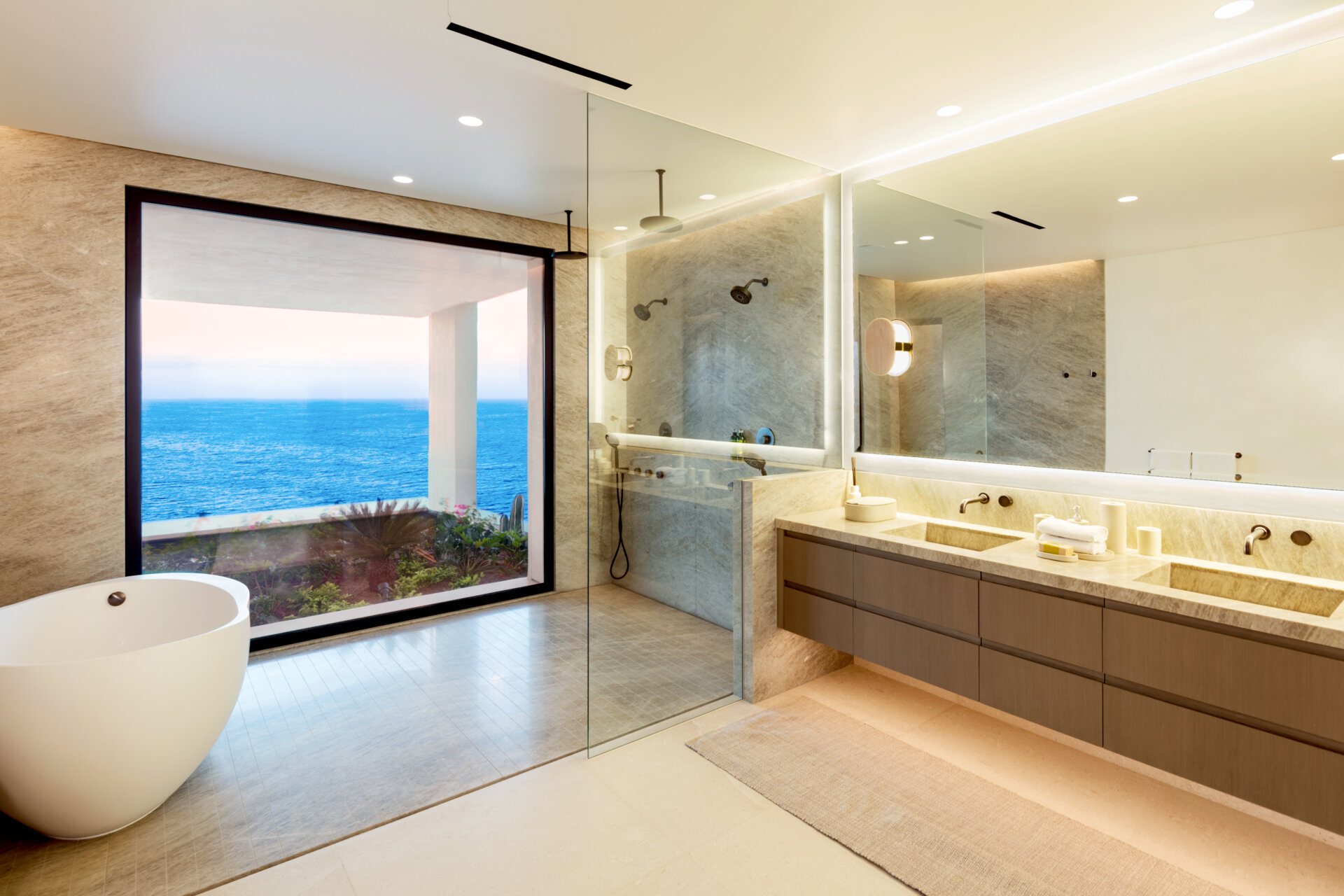 Warm lighting, tactile materials, and indoor-outdoor connections give these Cabo condo bathrooms a calm, luxurious feel.