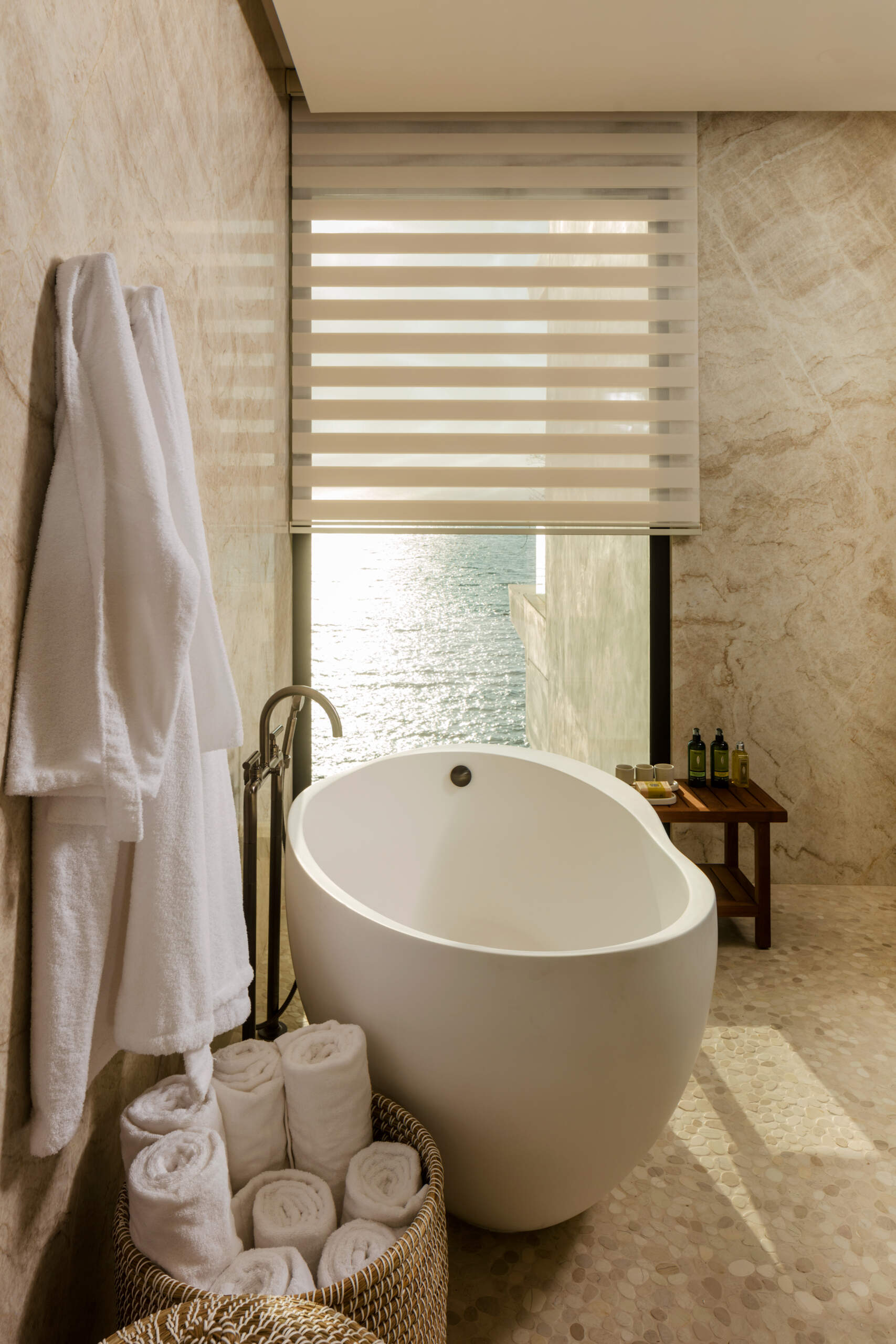 Warm lighting, tactile materials, and indoor-outdoor connections give these Cabo condo bathrooms a calm, luxurious feel.