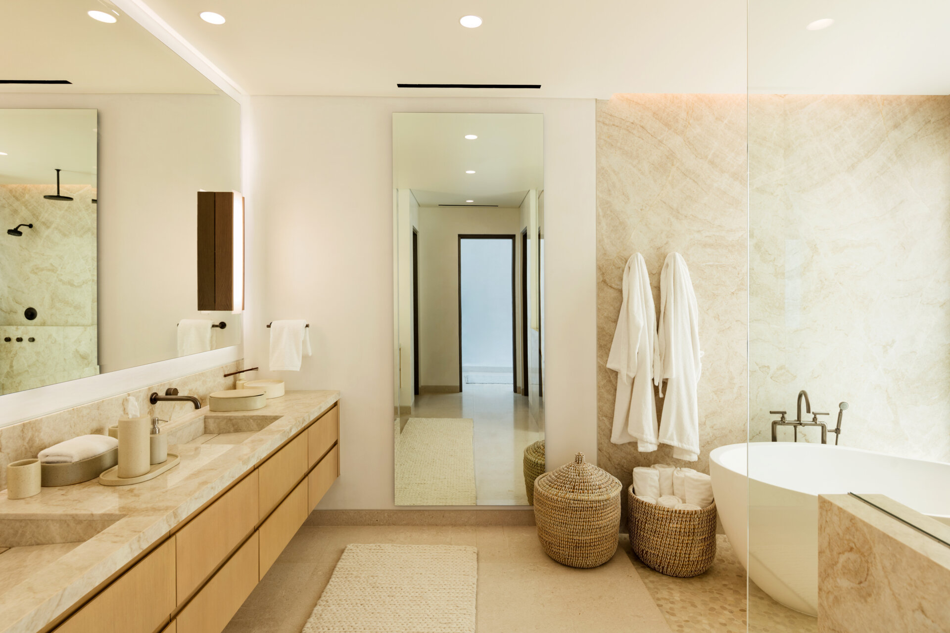 Warm lighting, tactile materials, and indoor-outdoor connections give these Cabo condo bathrooms a calm, luxurious feel.